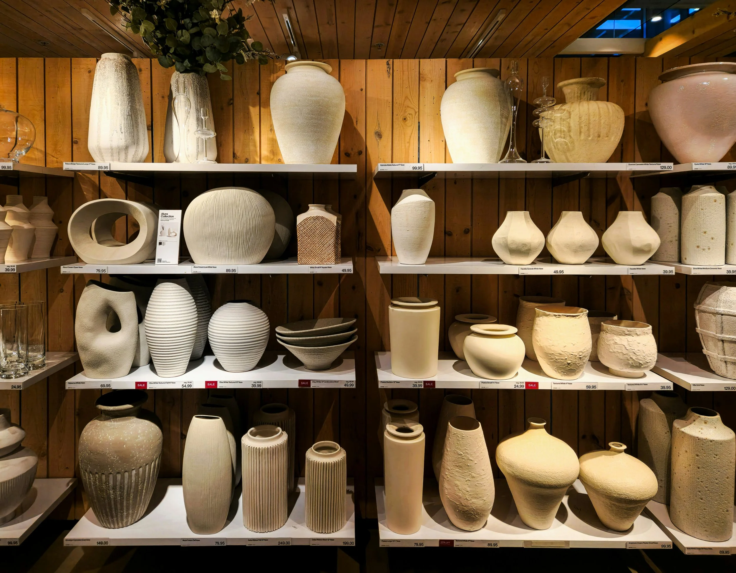 Curated home decor products including furniture, ceramics, and textiles styled in a natural light setting.