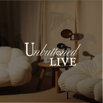 Living room with beige and white furniture, a wooden side table, and a tripod floor lamp with a wooden shade, featuring the text 'Unbuttoned Live' overlayed.