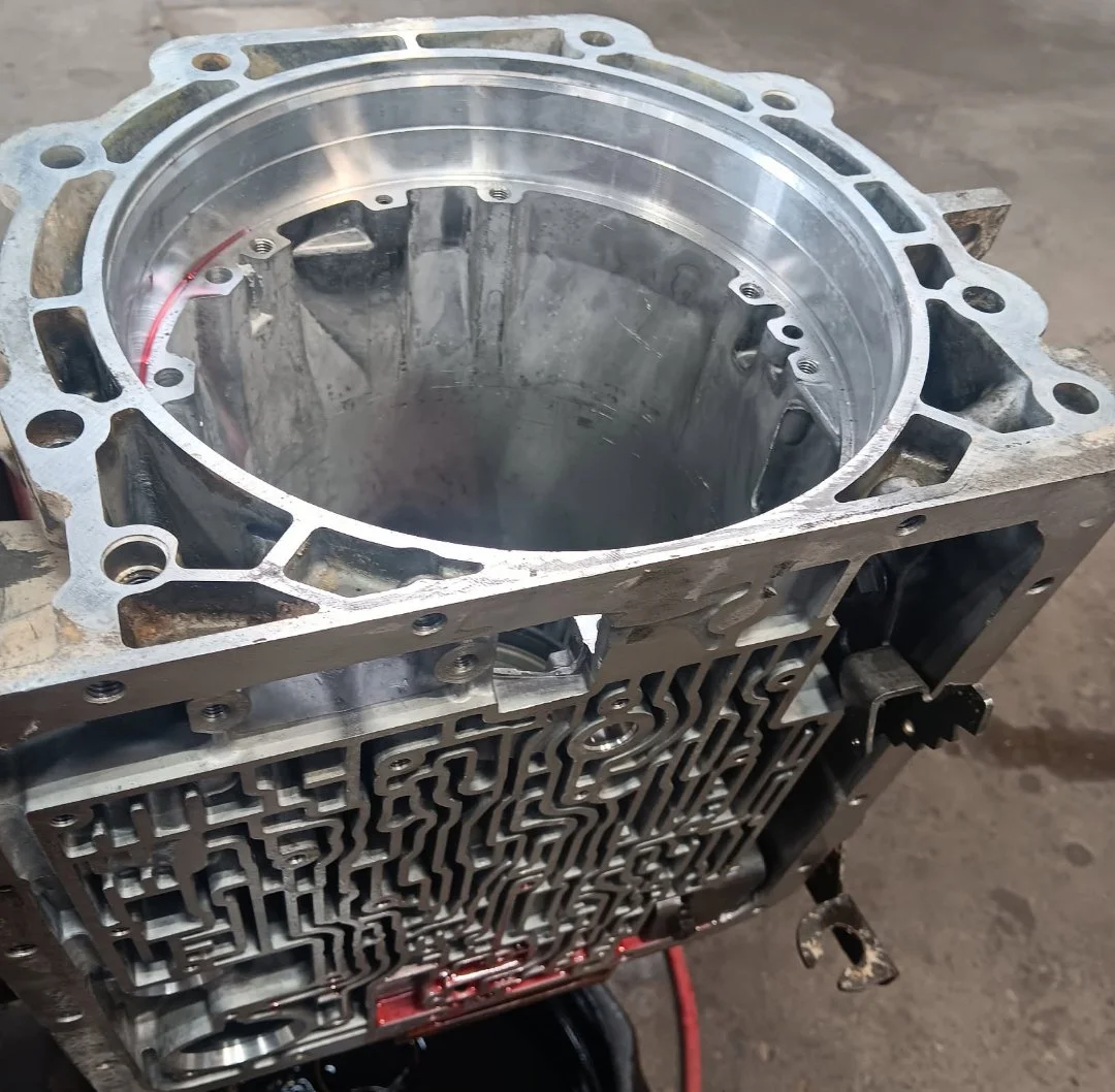 A close-up view of a metallic engine block, showing the cylinder bore and intricate internal machined components.
