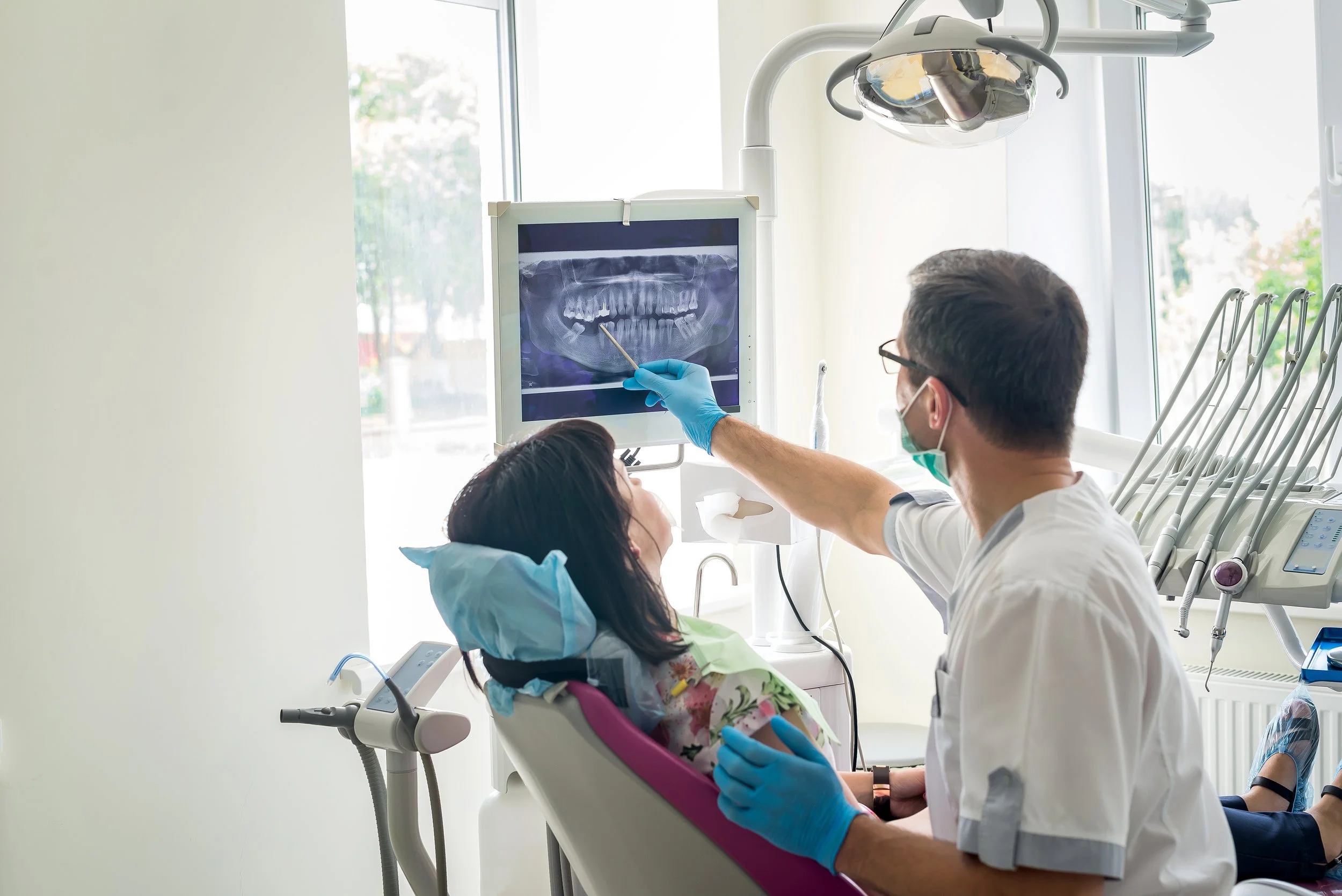 Dentist showing a dental x-ray to a patient in a dental office.