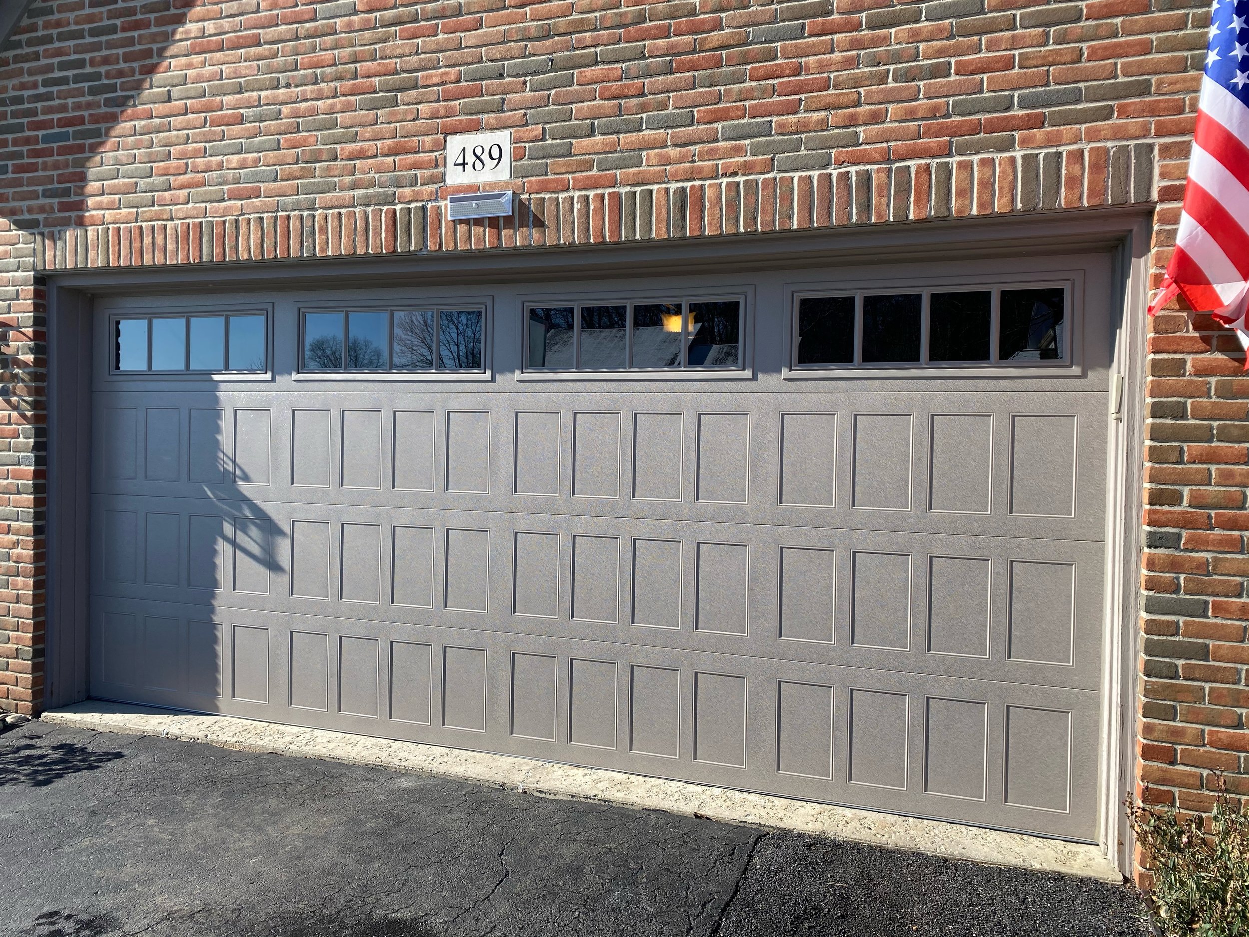 One Grey Stamped Shaker Garage Door on Brick House