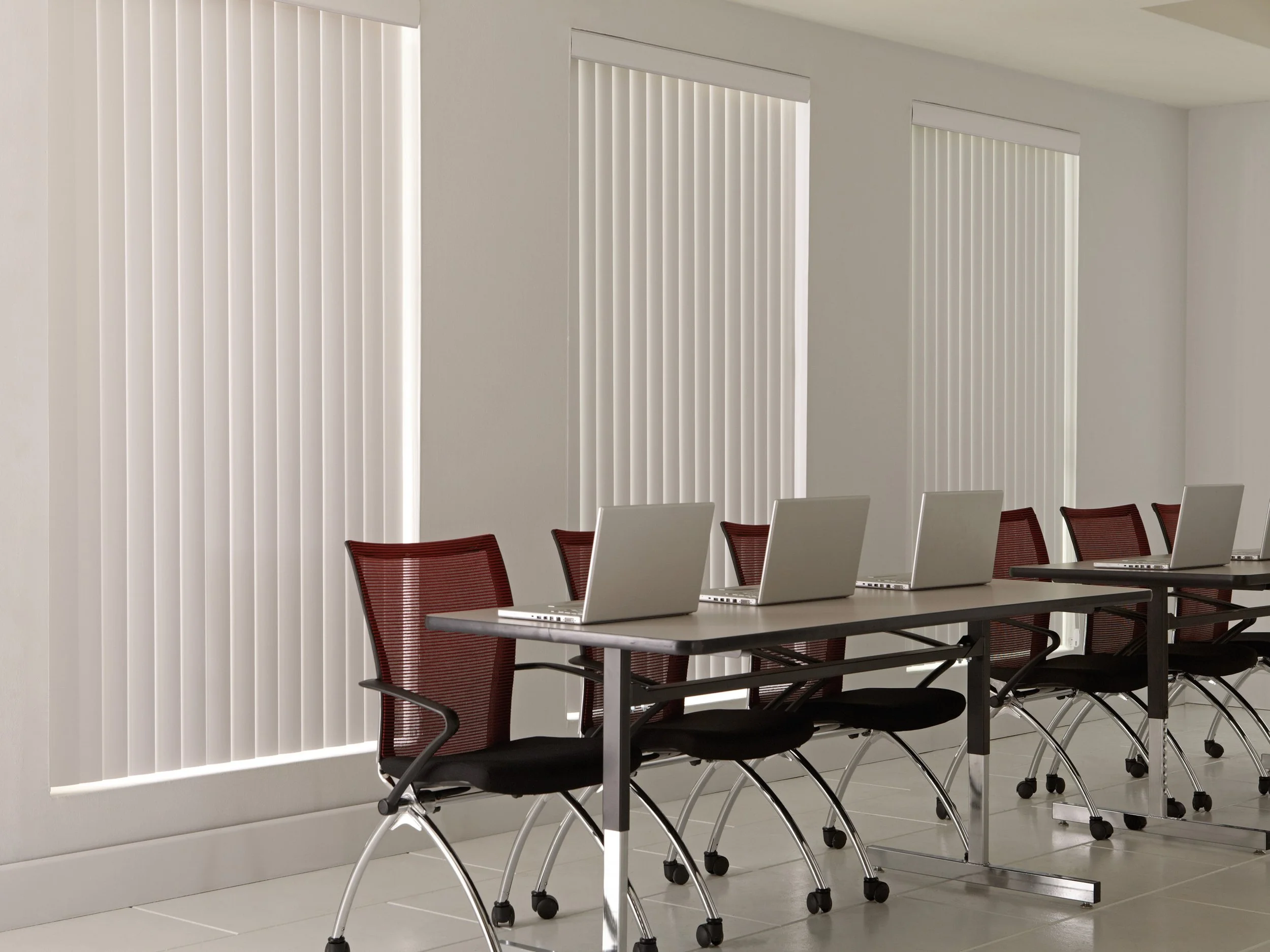 Closed white vertical blinds in an office