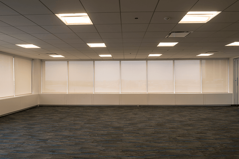 A room of white Roller/Solar shades with a Steel chain and white fascia in an office building. Lansing Michigan