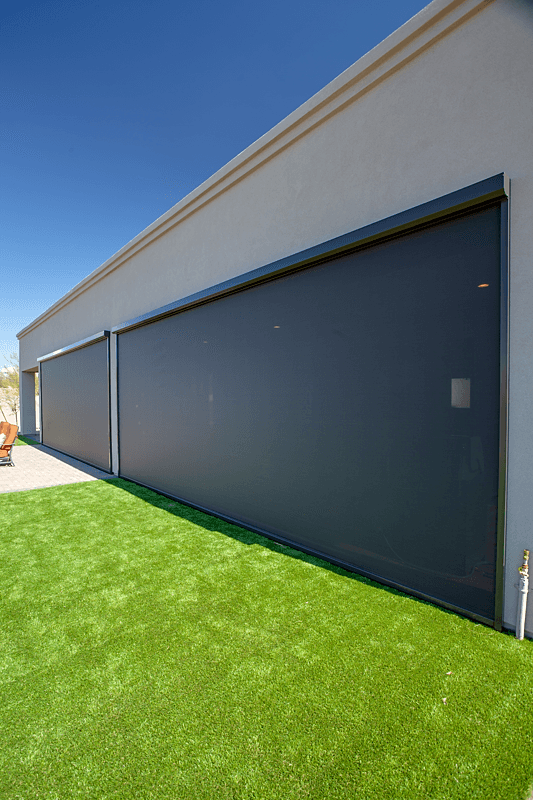 Motorized black ZIP Shade on the outside of a patio.