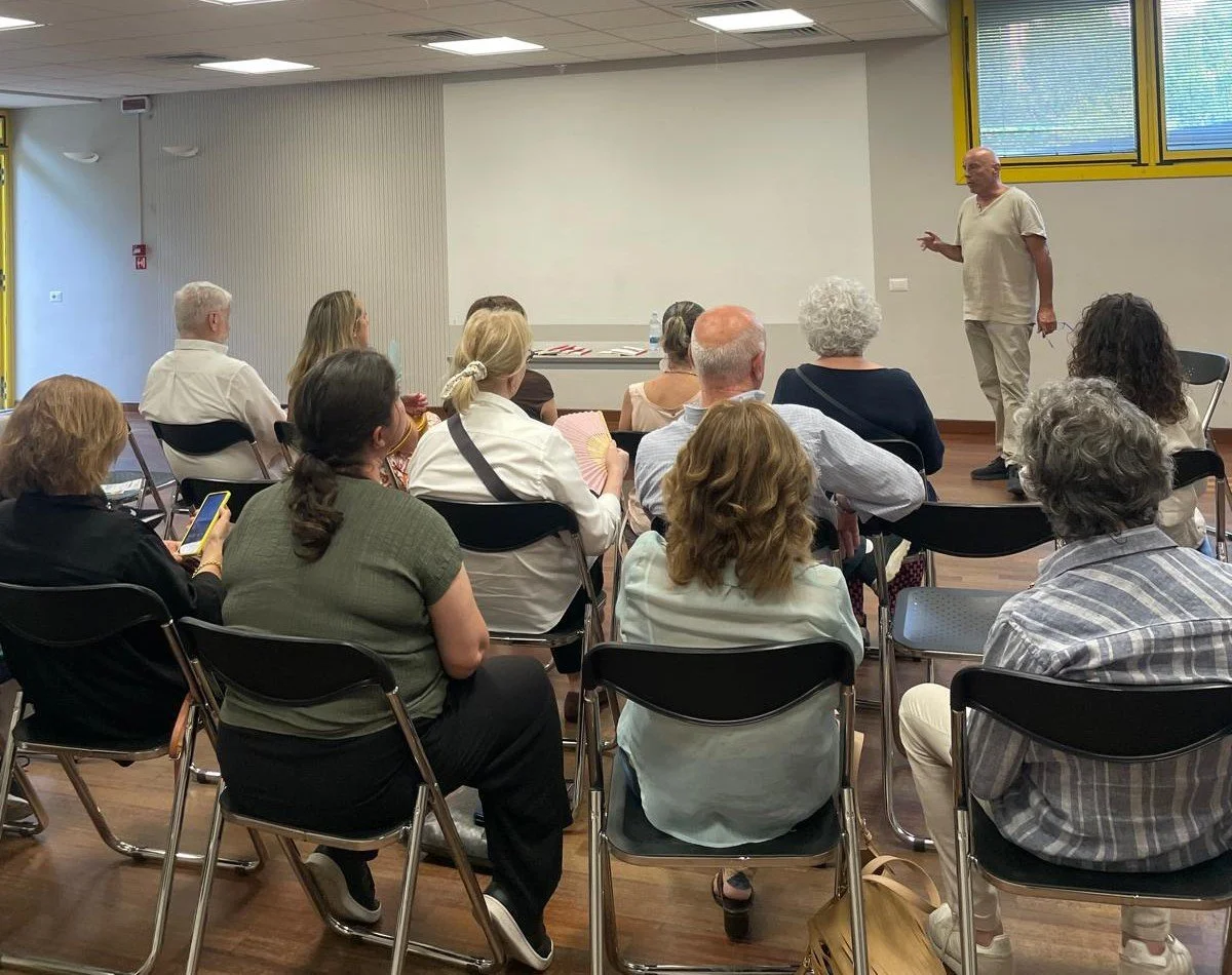 Foto con pubblico seduto di spalle nella sala Crespi del Centro Civico Liberthub di Monza. Sullo sfondo autore del libro "Siamo papà", Paolo Gioia.