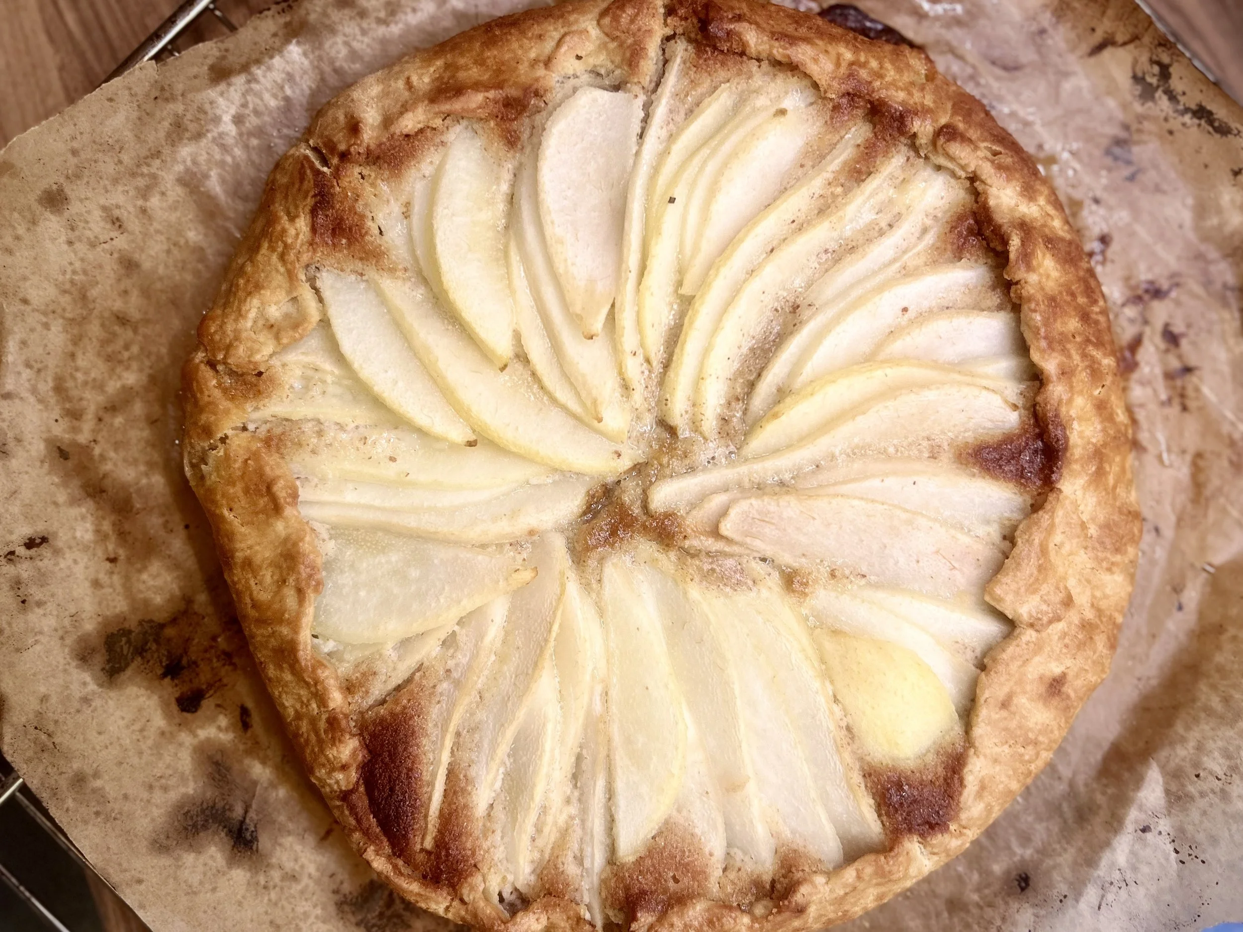 A pear tart with sliced pears arranged in a circular pattern on top of a pastry crust.