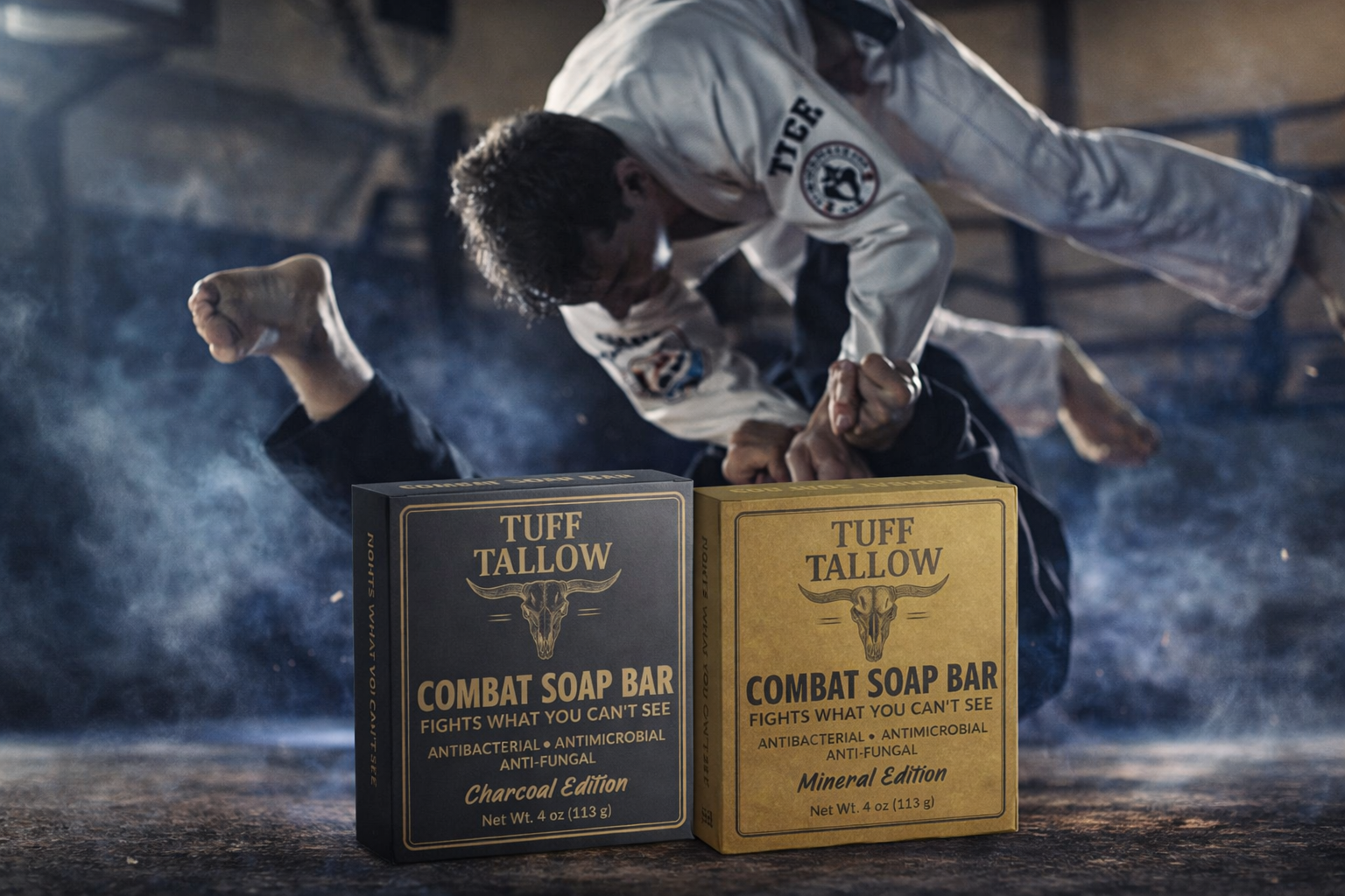 Two boxes of Tuff Tallow combat soap bars, Charcoal Edition and Mineral Edition, with a MMA fighter in Gi performing a ground grappling move in a rugged setting.