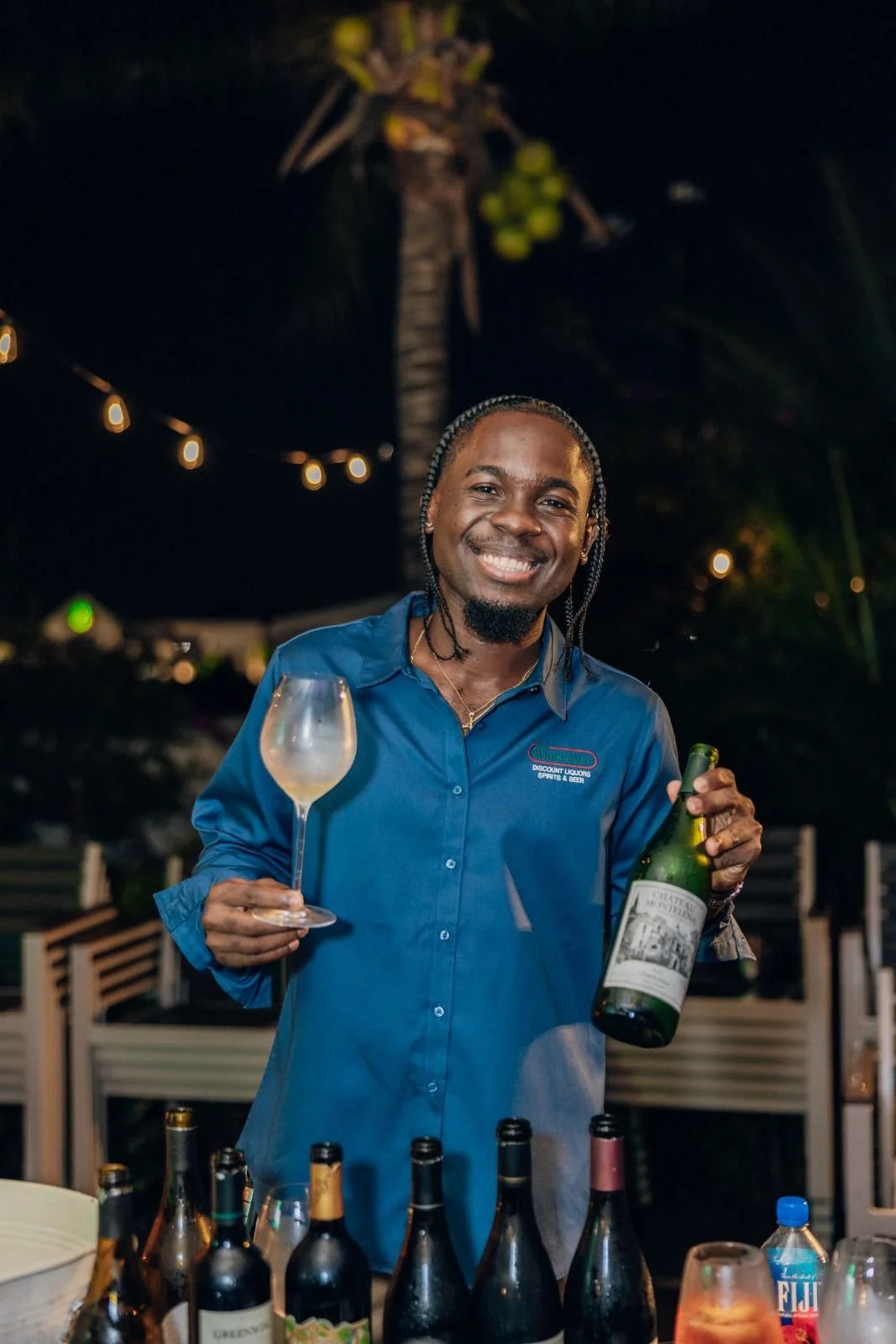Modern house with wooden facade and large window in a mountainous landscape with dry grass and shrubs.