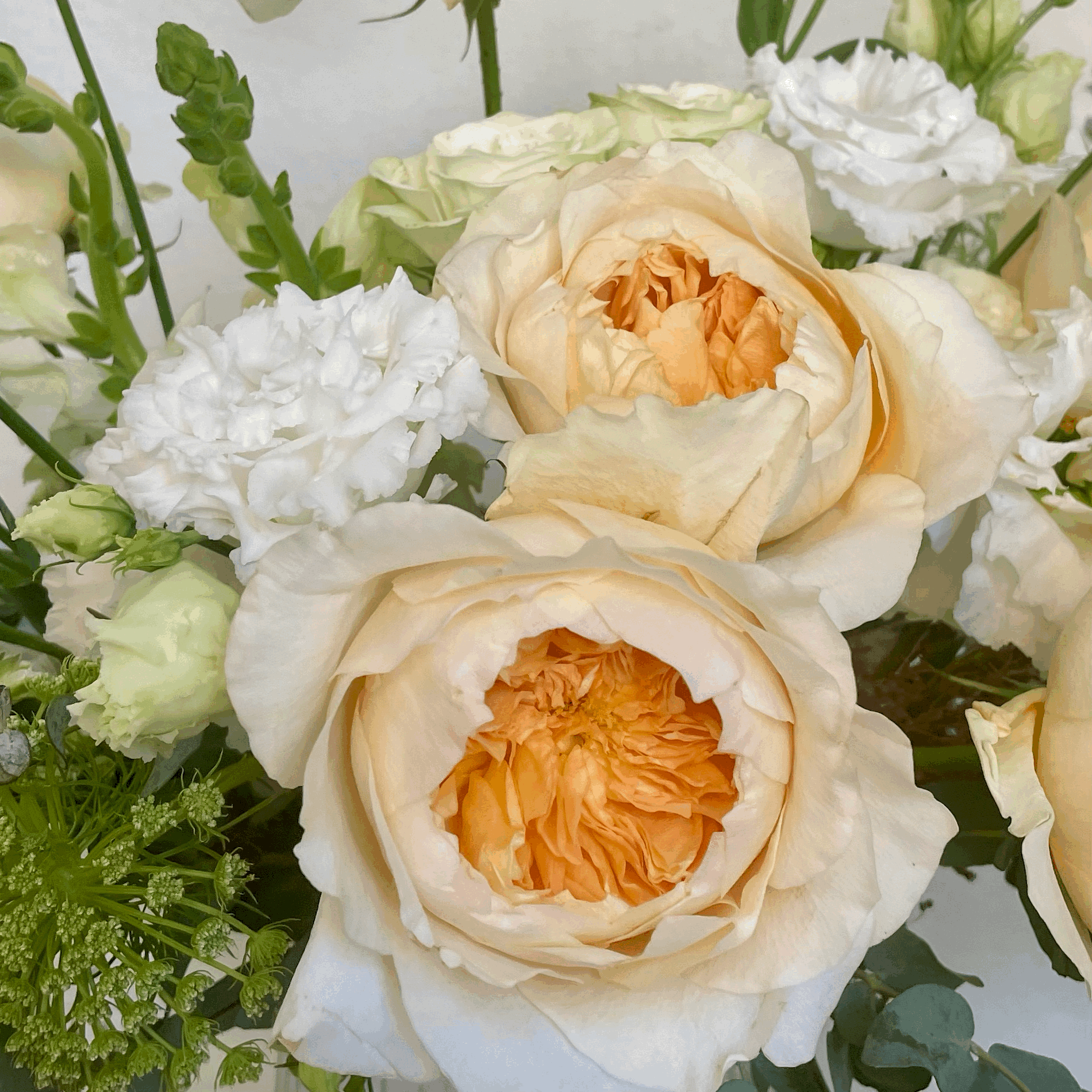 large neutral arrangement with close up of pastel flowers