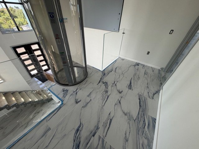 Interior tile flooring with white marble tile and gray grout