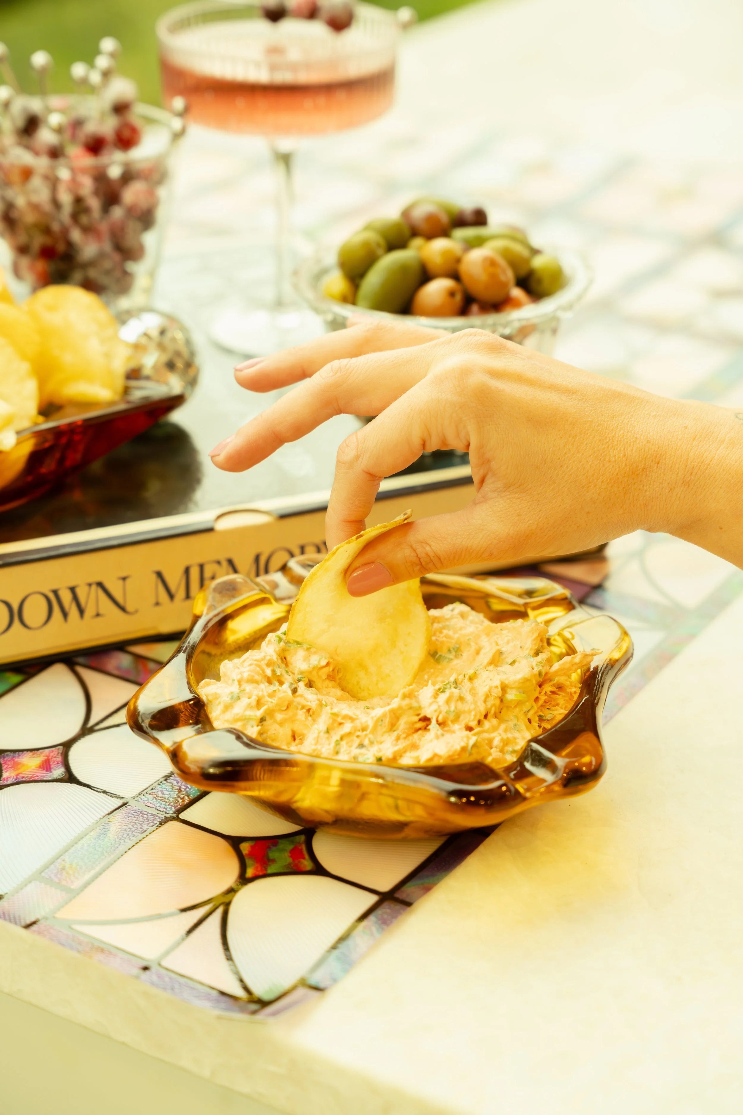 Salmon dip with hand made chips, in the background vintage vinyl records, olives and cocktail glass