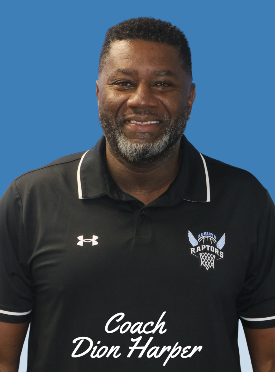 Close-up of a young woman with shoulder-length black hair, smiling with teeth visible, wearing a blue top, surrounded by green plants.
