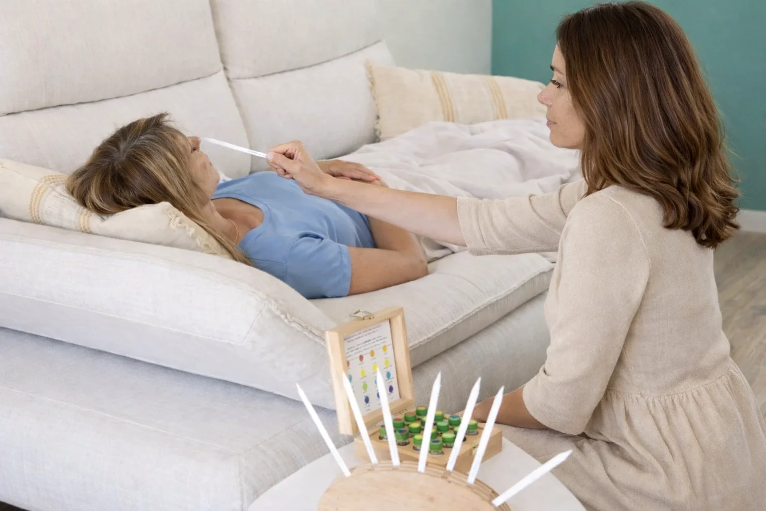 Une femme prend la température d'une jeune fille malade allongée sur un canapé, un jeu de société à côté.