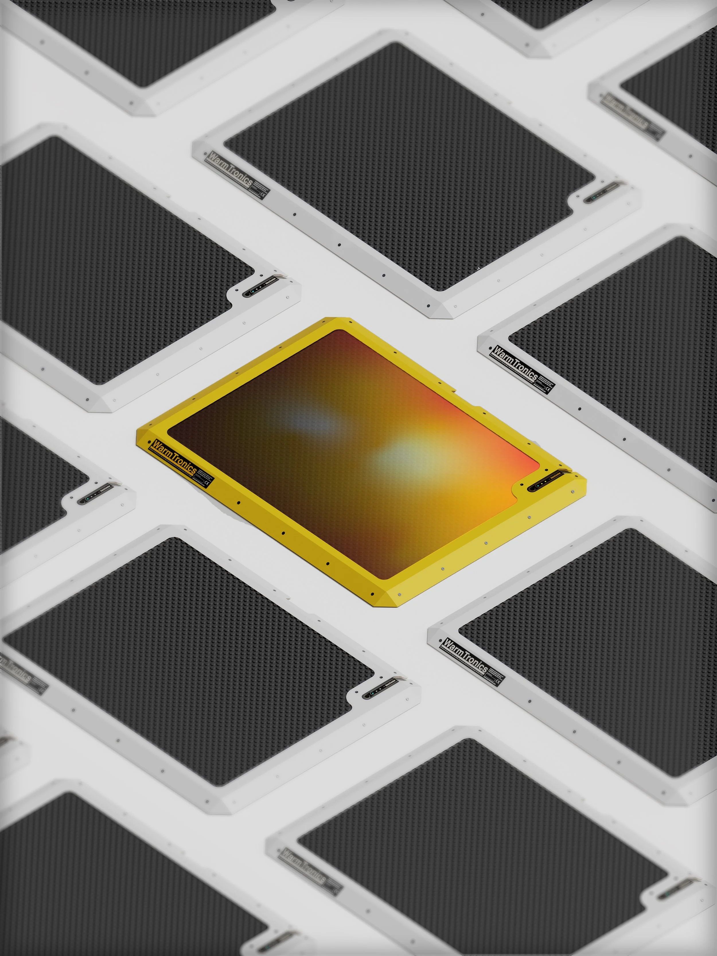 Multiple square devices with black grates, one with a yellow frame, labeled WarmTronics, arranged in a grid pattern.