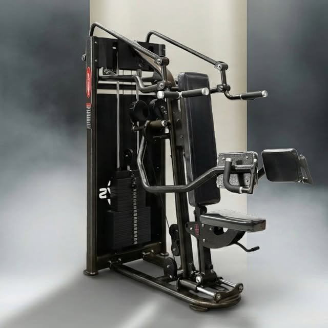 A multi-function gym machine with various workout attachments in a fitness center.