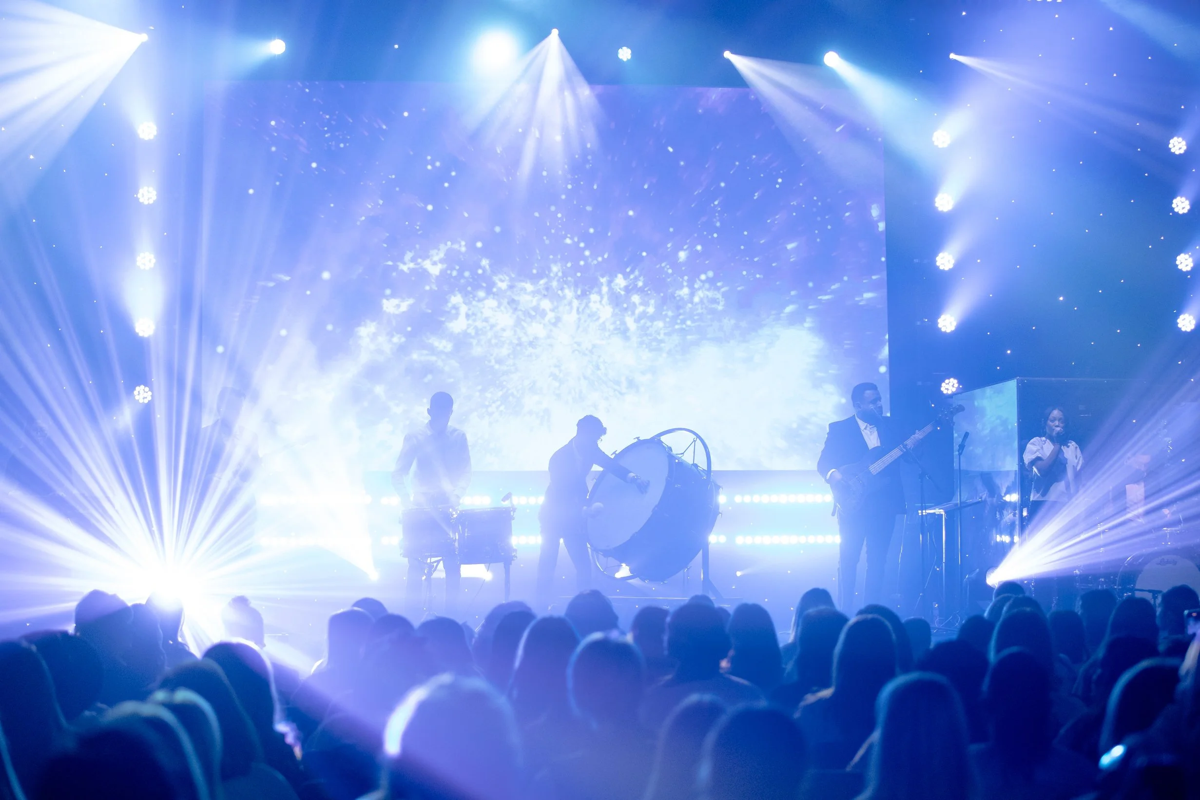 High-energy live concert performance with cinematic stage lighting, musicians on stage, LED screen visuals, and a full audience in Houston, Texas. Professional event photography capturing atmosphere, production, and live entertainment.
