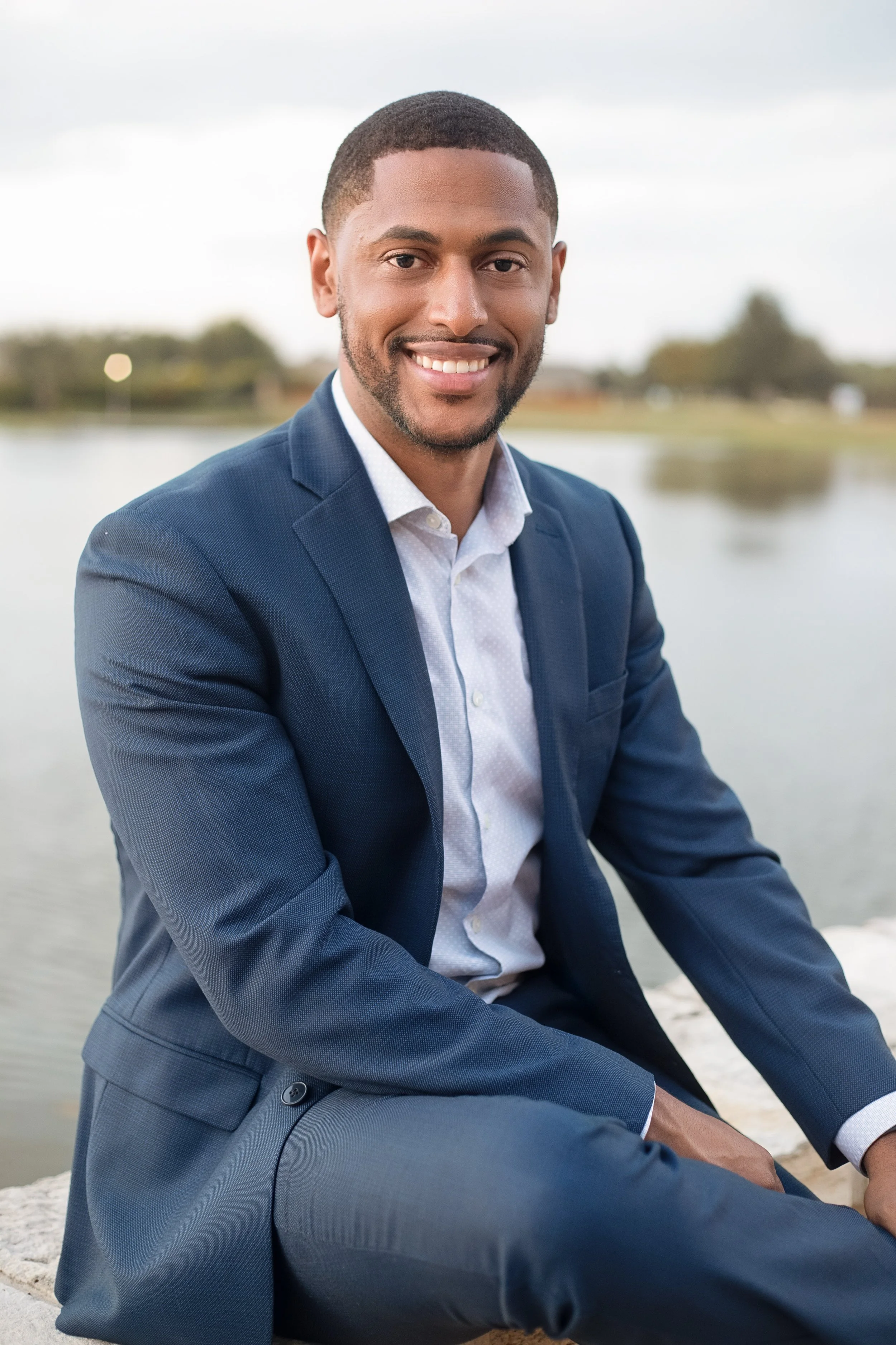 Professional business headshot featuring a confident male executive in a suit photographed outdoors with soft natural light. Premium headshot photography by Dominic Alvarez Photography serving Houston, Katy, and surrounding areas across Southeast Tex