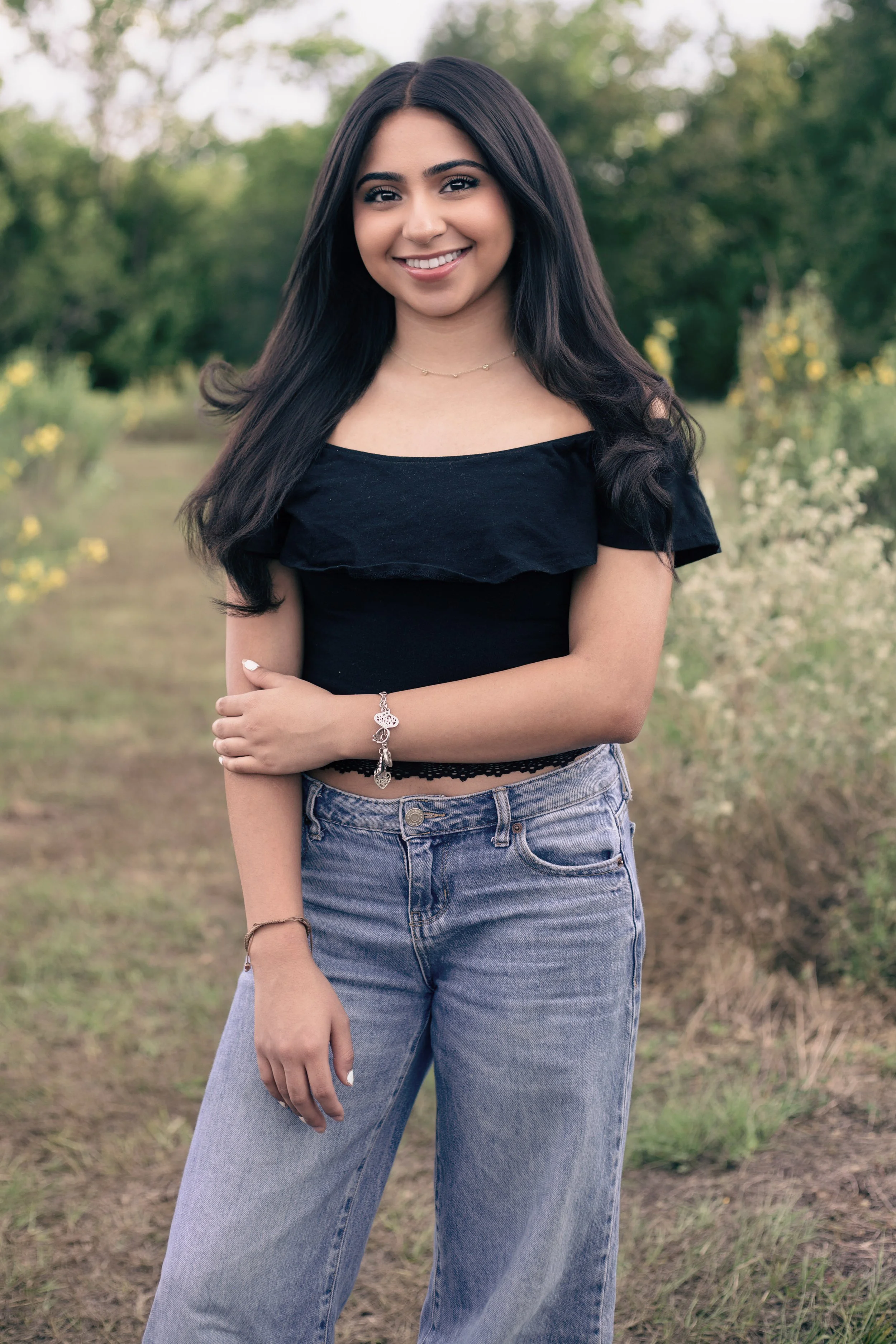 High school senior portrait featuring a smiling female senior in a natural outdoor setting with soft light and a relaxed, modern style. Professional senior photography by Dominic Alvarez Photography serving Houston, Katy, and surrounding areas across