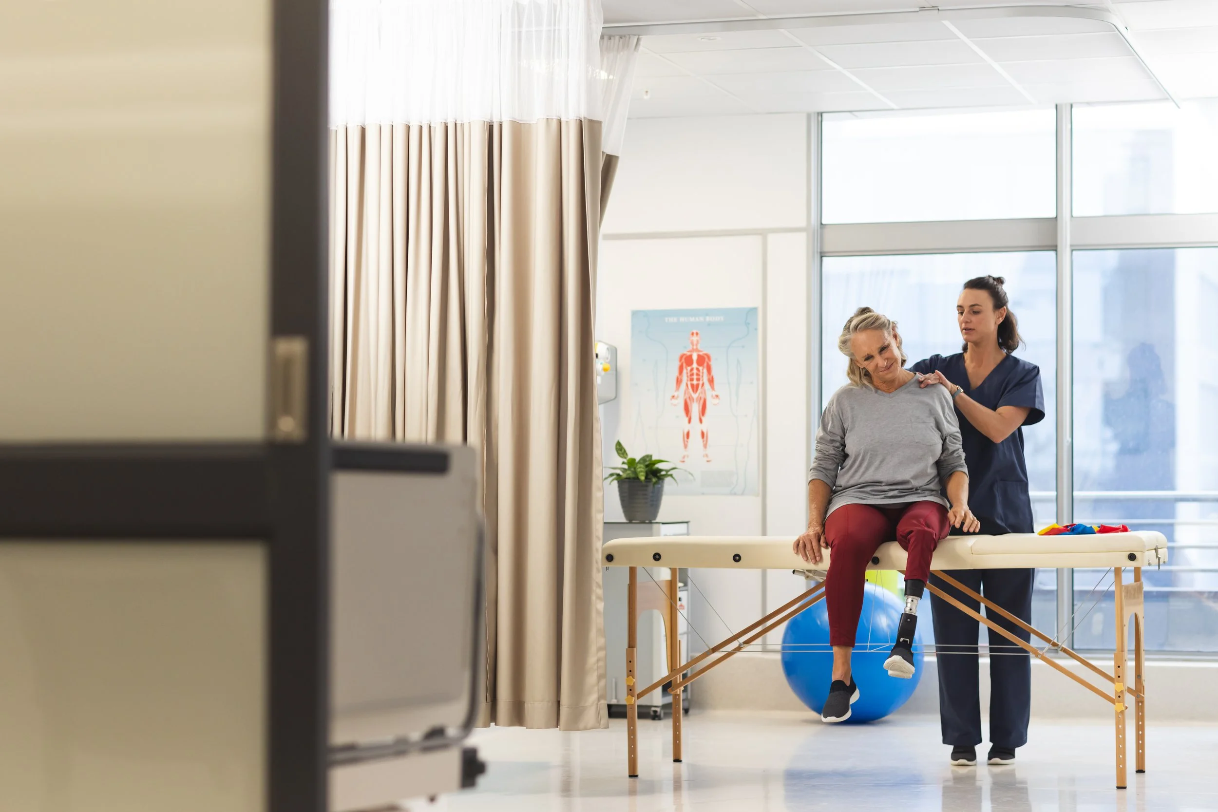 MD BioTek, Inc. | Trusted Physical Therapy and Medical Equipment Service | A physical therapist assists a woman with a prosthetic leg during a rehabilitation session in a medical clinic.