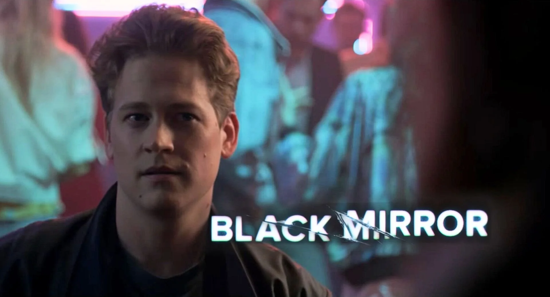 A young man with light brown hair looking to his left, with neon and dark background, and the words 'BLACK MIRROR' visible at the bottom.