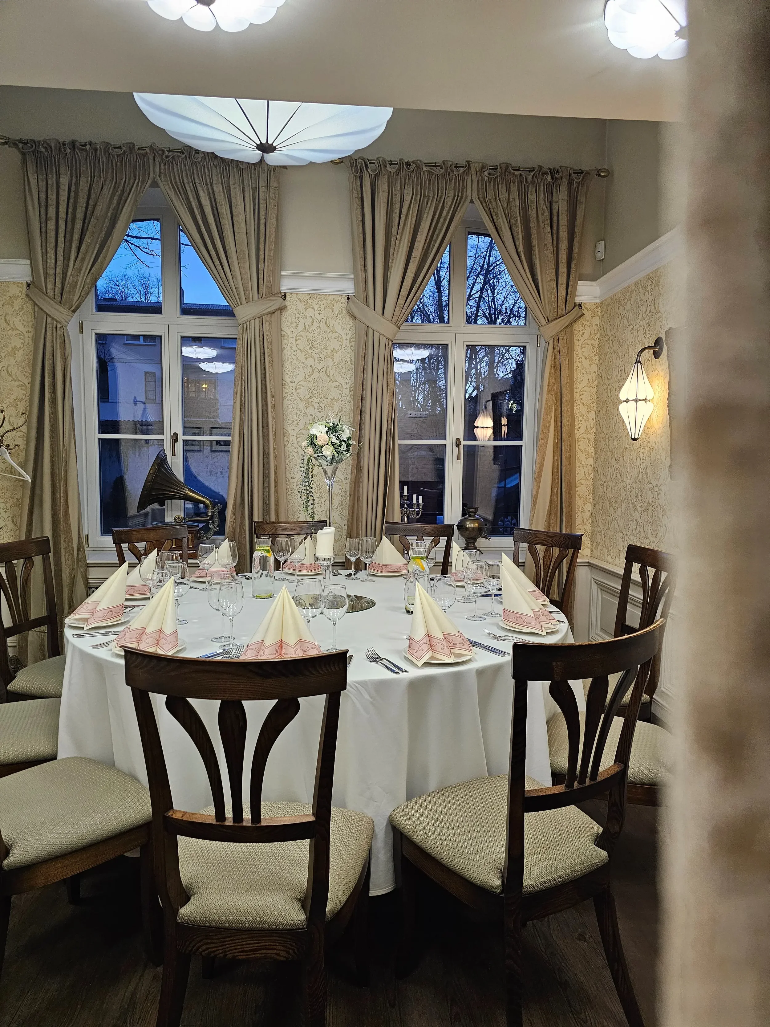 Apvalus stalas, šventiškai paserviruotas vakarieinei ar šventei restorane „XIX amžius“.