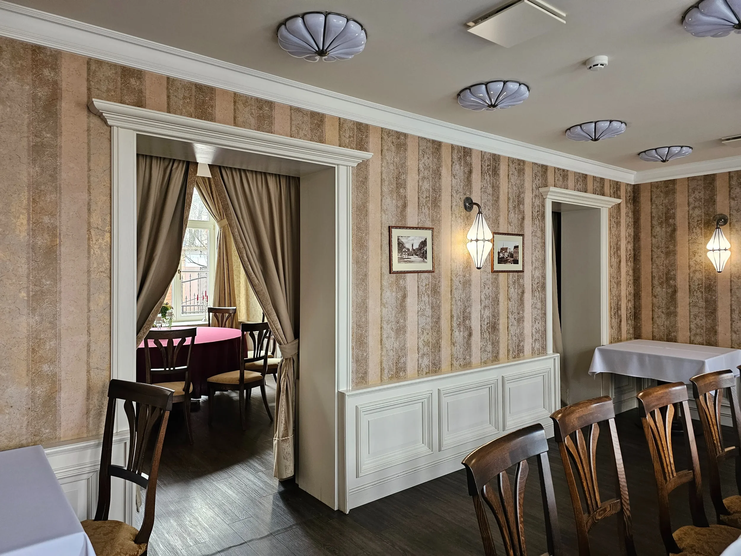 Jaukus restorano „XIX amžius“ interjeras su istoriniais motyvais ir mediniais baldais.