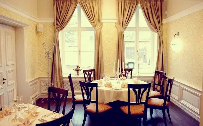 Elegantiška privati restorano erdvė su apvaliu stalu, paruošta šeimos šventei Klaipėdoje.