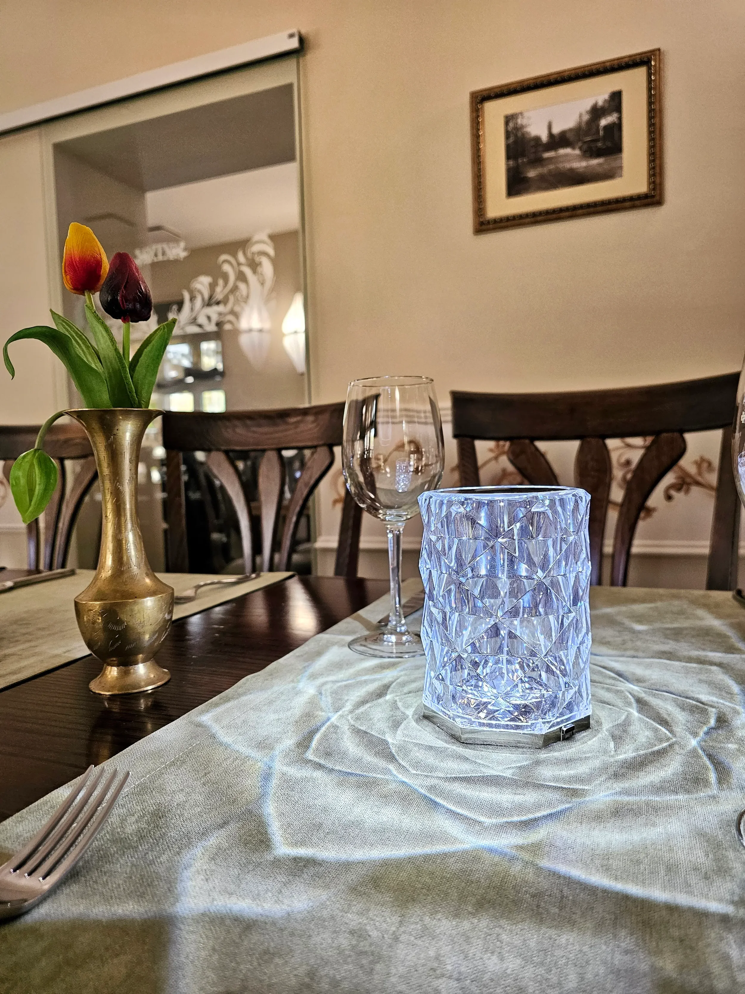 Restorano stalo serviruotė su tulpėmis ir istoriniu Klaipėdos paveikslu fone.