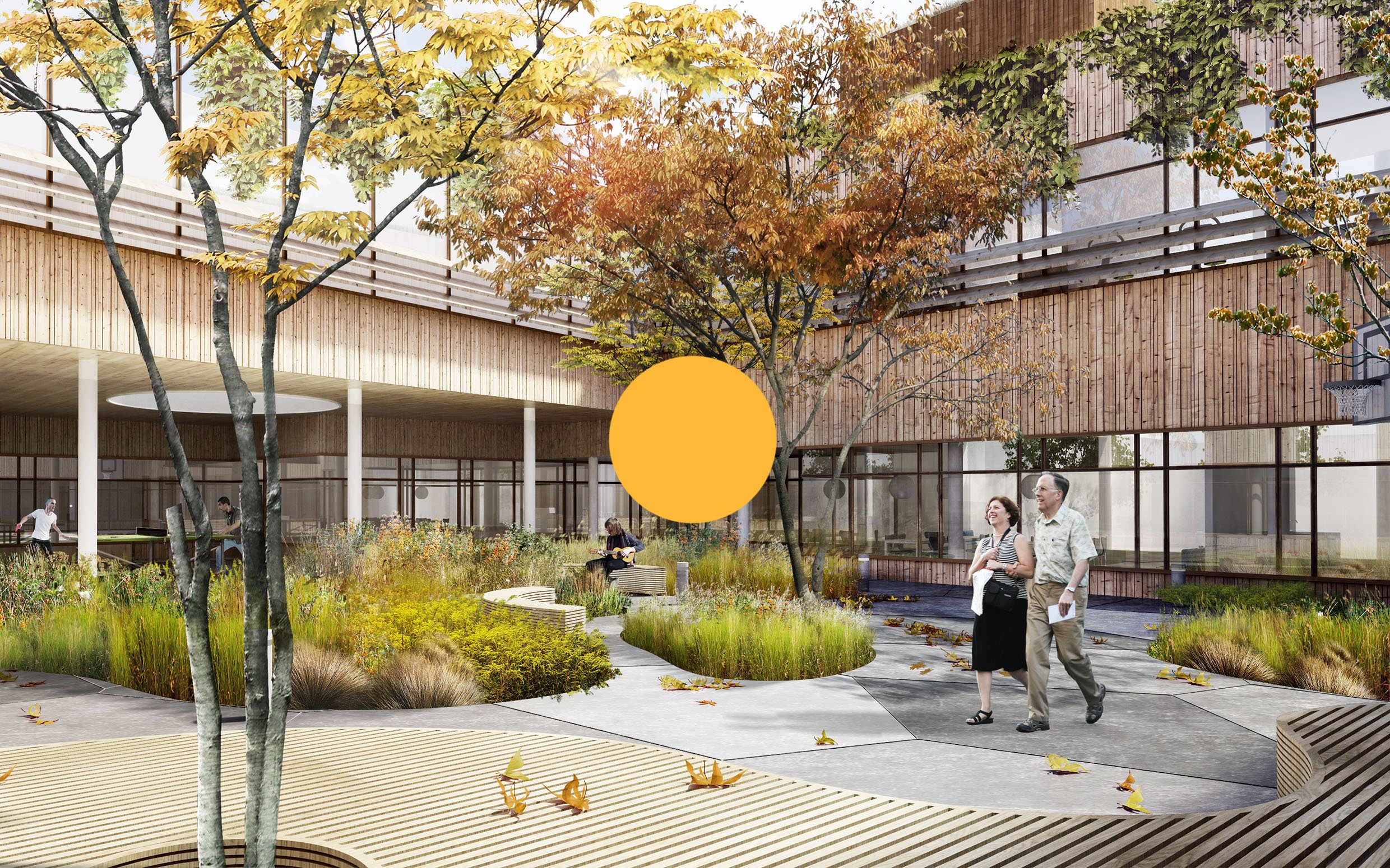 Modern outdoor courtyard with trees, plants, benches, and a pathway, featuring people walking and sitting, with a glass building in the background and fall leaves scattered on the ground.