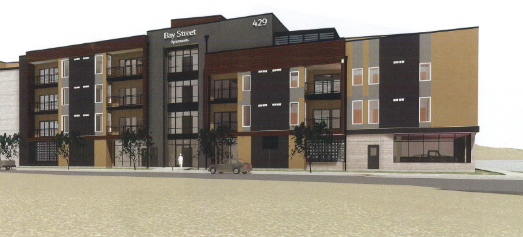 Modern multi-story apartment building with balconies, trees, and parking area in front.