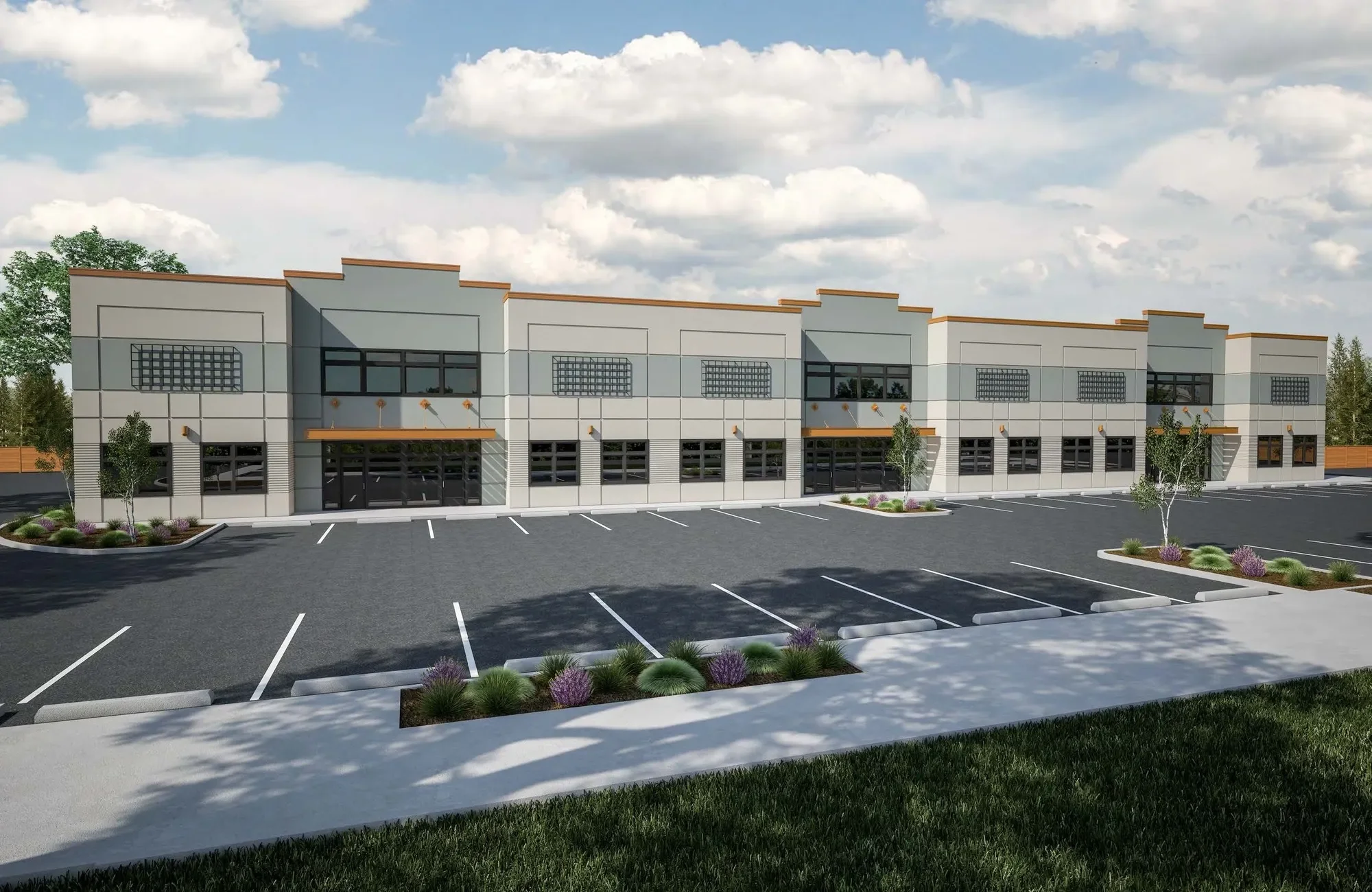 A modern two-story commercial building with large windows and a spacious parking lot in front, surrounded by landscaped areas with small trees and purple bushes under a partly cloudy sky.