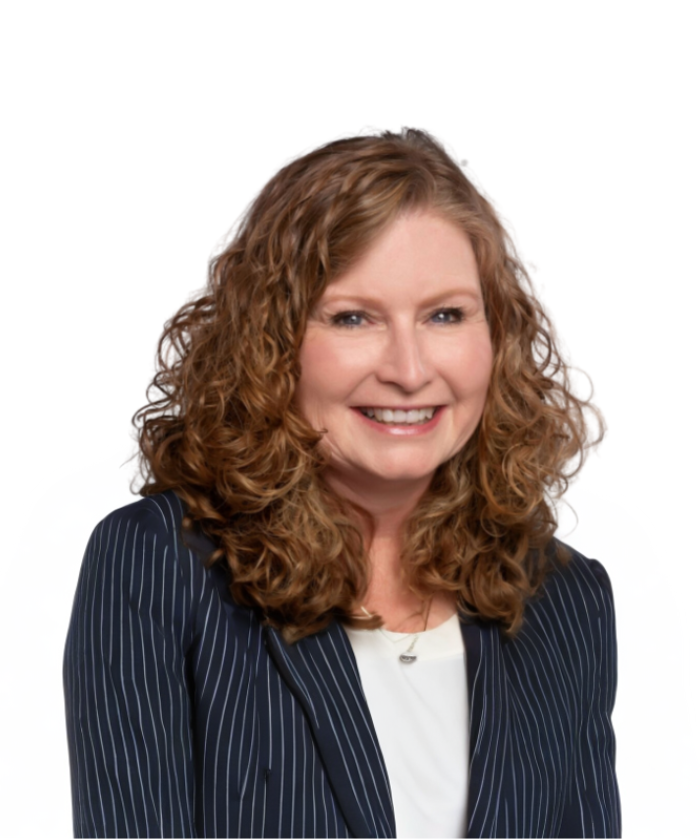 A woman with curly red hair smiling at the camera, wearing a navy pinstripe blazer over a white shirt, against a plain white background.