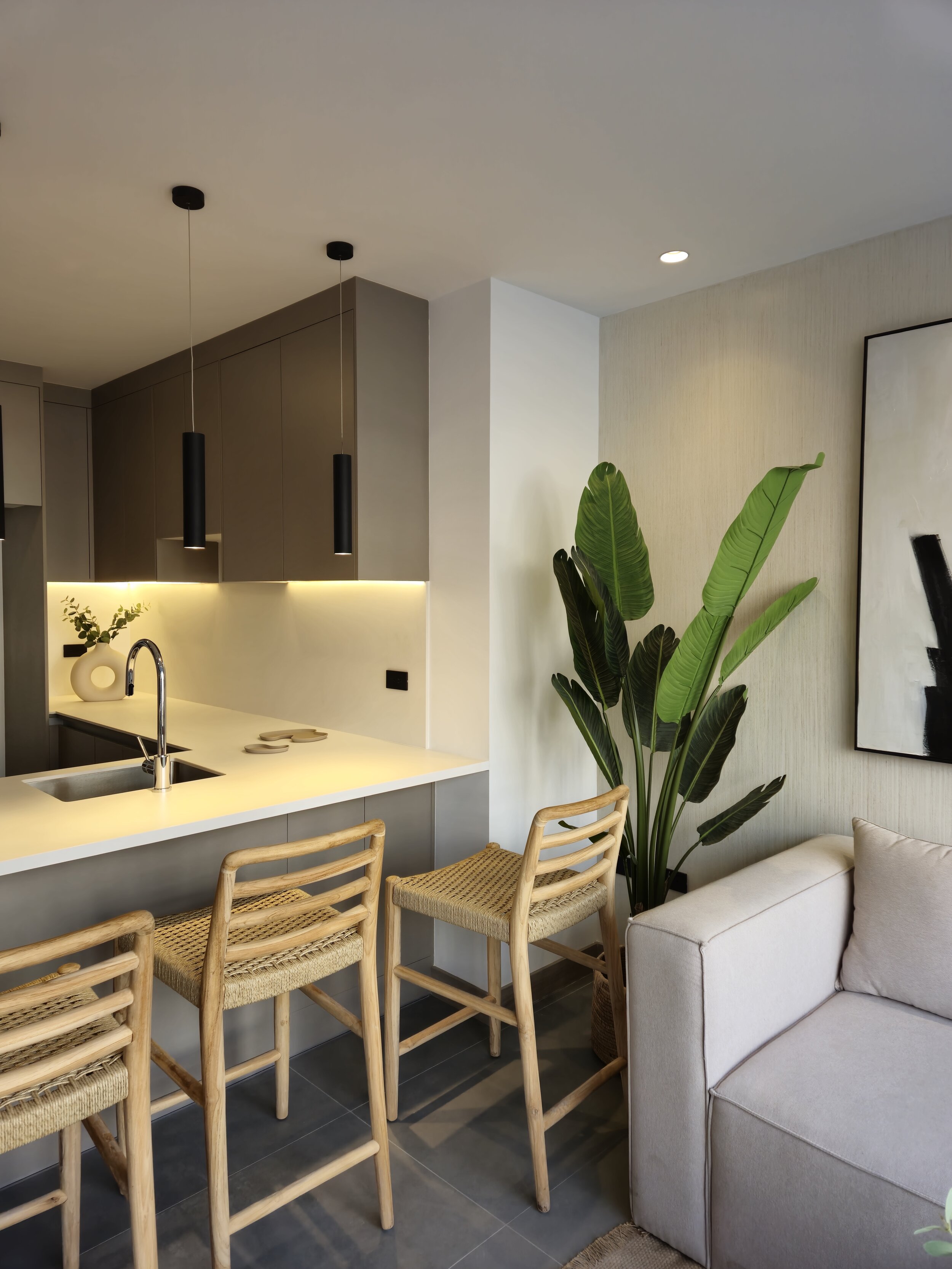 Decoración moderna en cocina y sala con plantas verdes y muebles de madera.