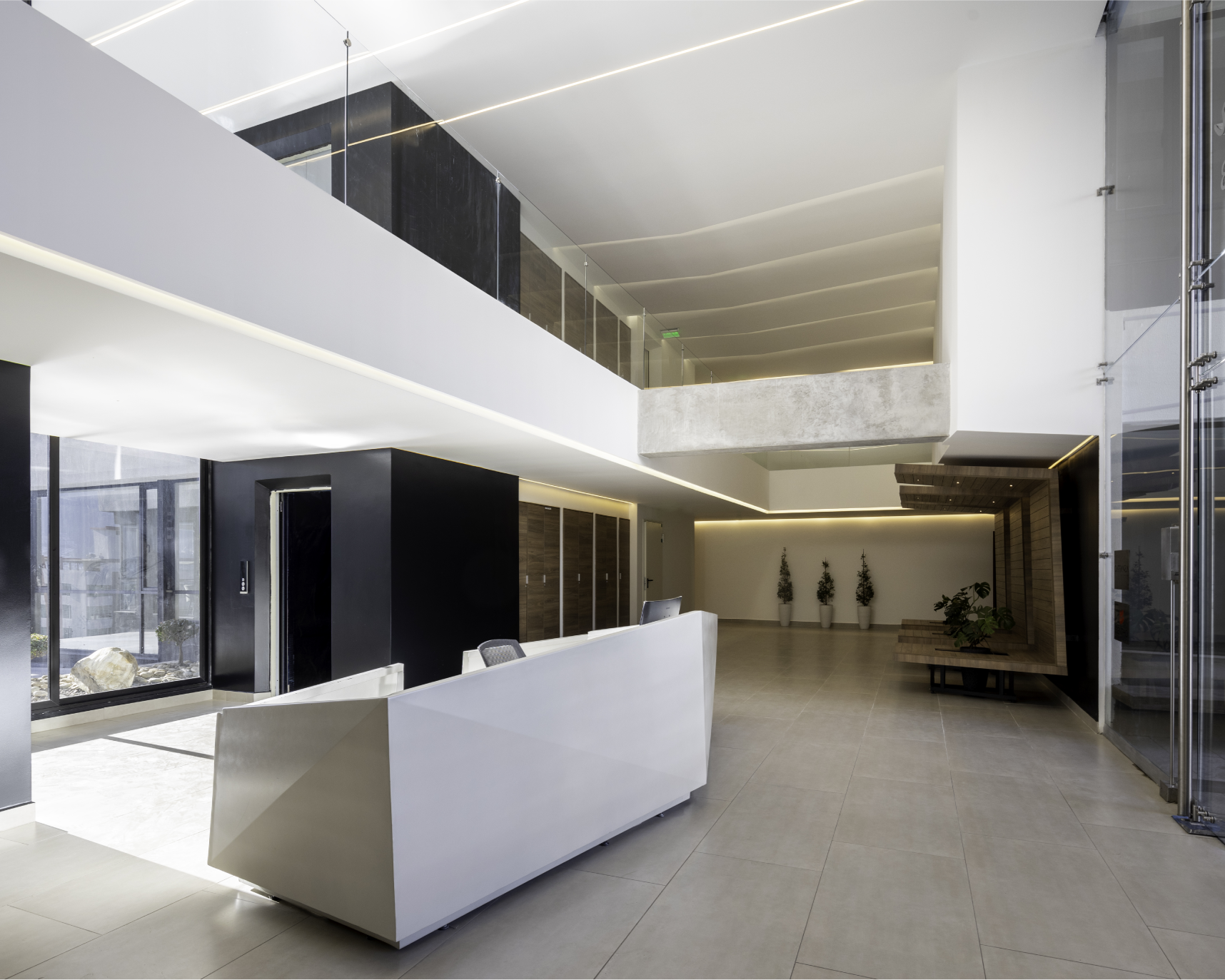 Vestíbulo moderno con sillón blanco, paredes negras y blancas, decoración minimalista, plantas en macetas, pasillo con paredes de madera y iluminación LED.