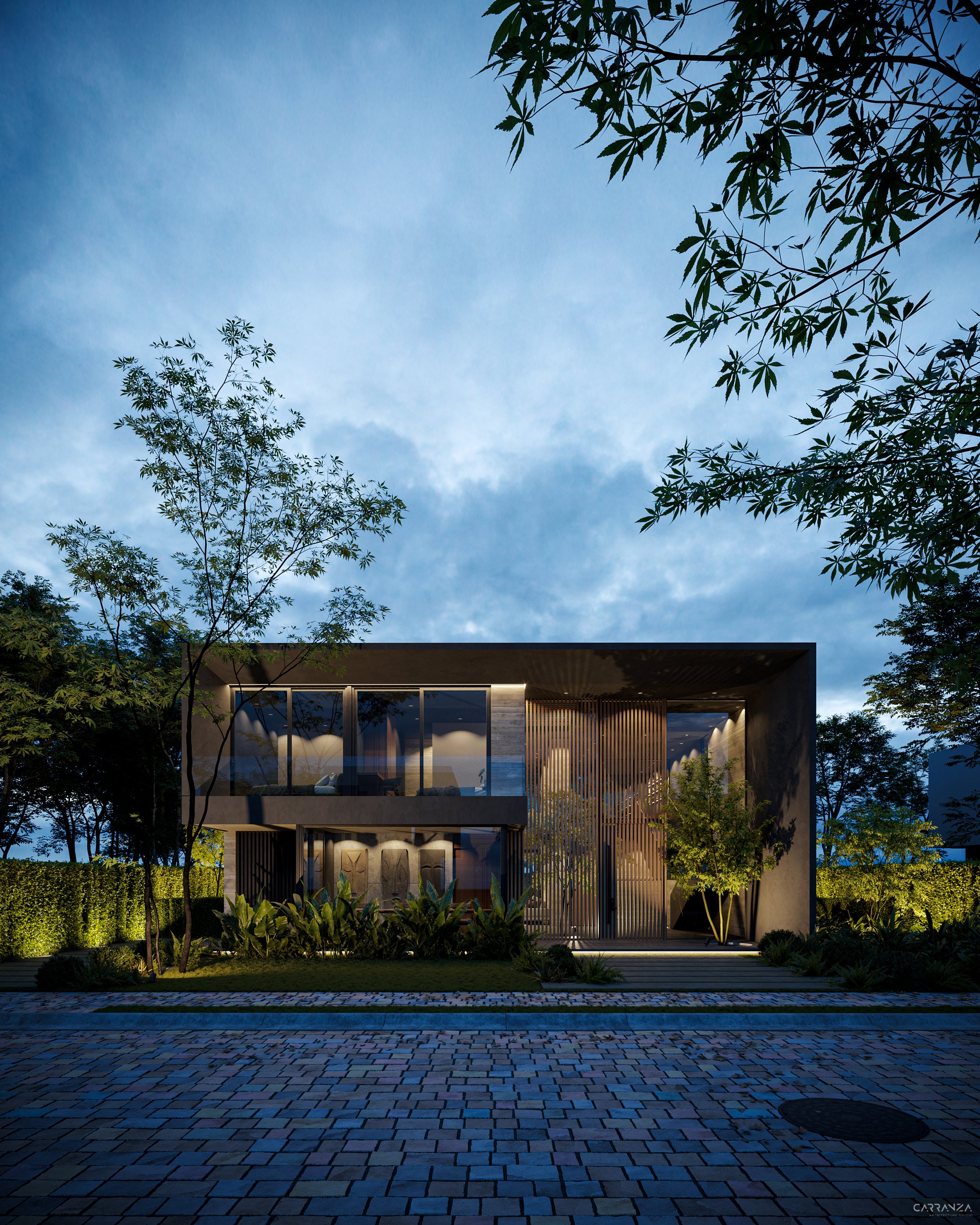 Casa moderna de dos pisos con ventanas grandes y jardines, iluminada por luces en la noche, rodeada de árboles y vegetación.