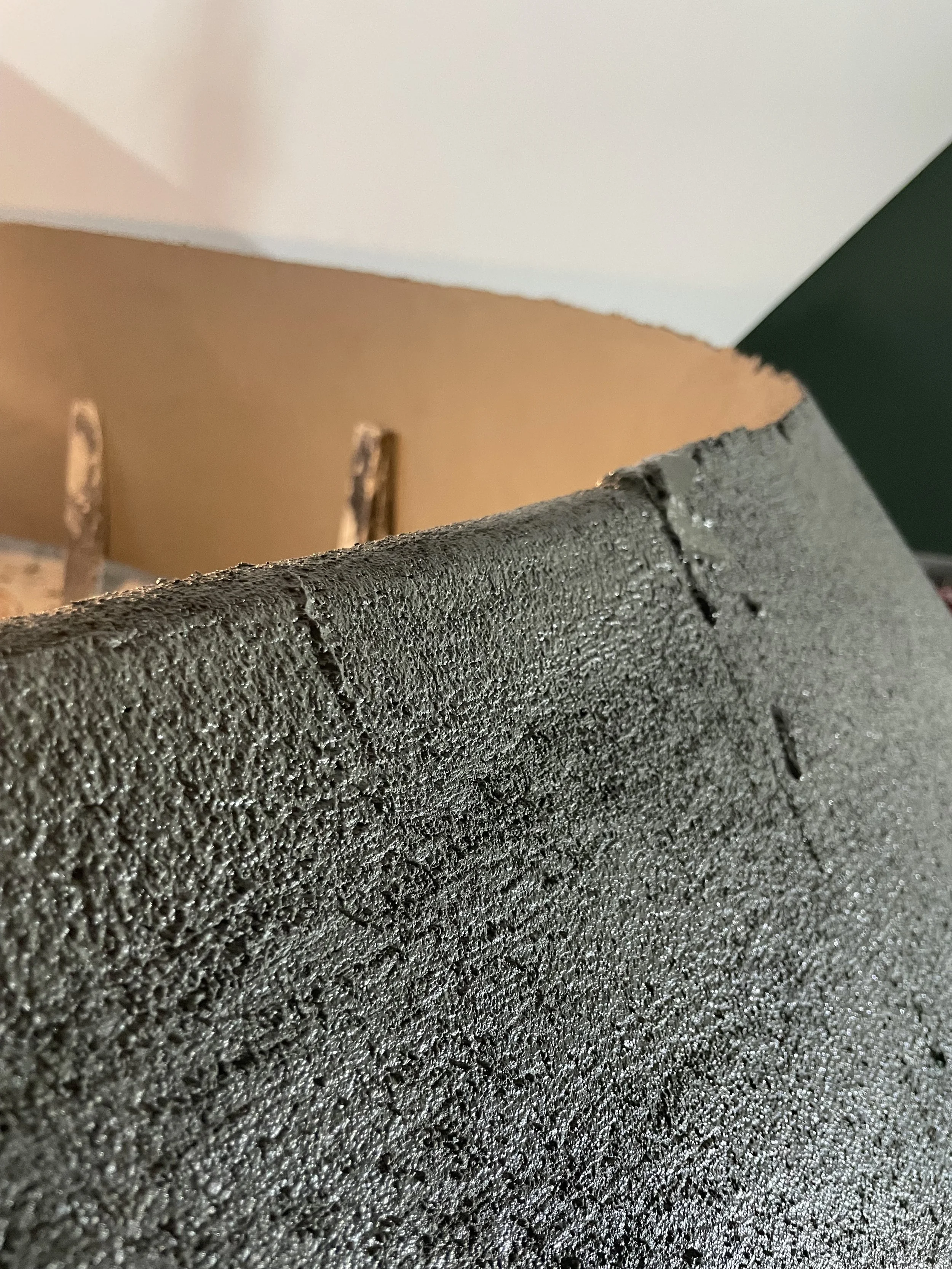 Enfoque cercano en la superficie de una pieza de espuma de poliestireno o poliestireno expandido, con una textura granulada y marcas de corte.