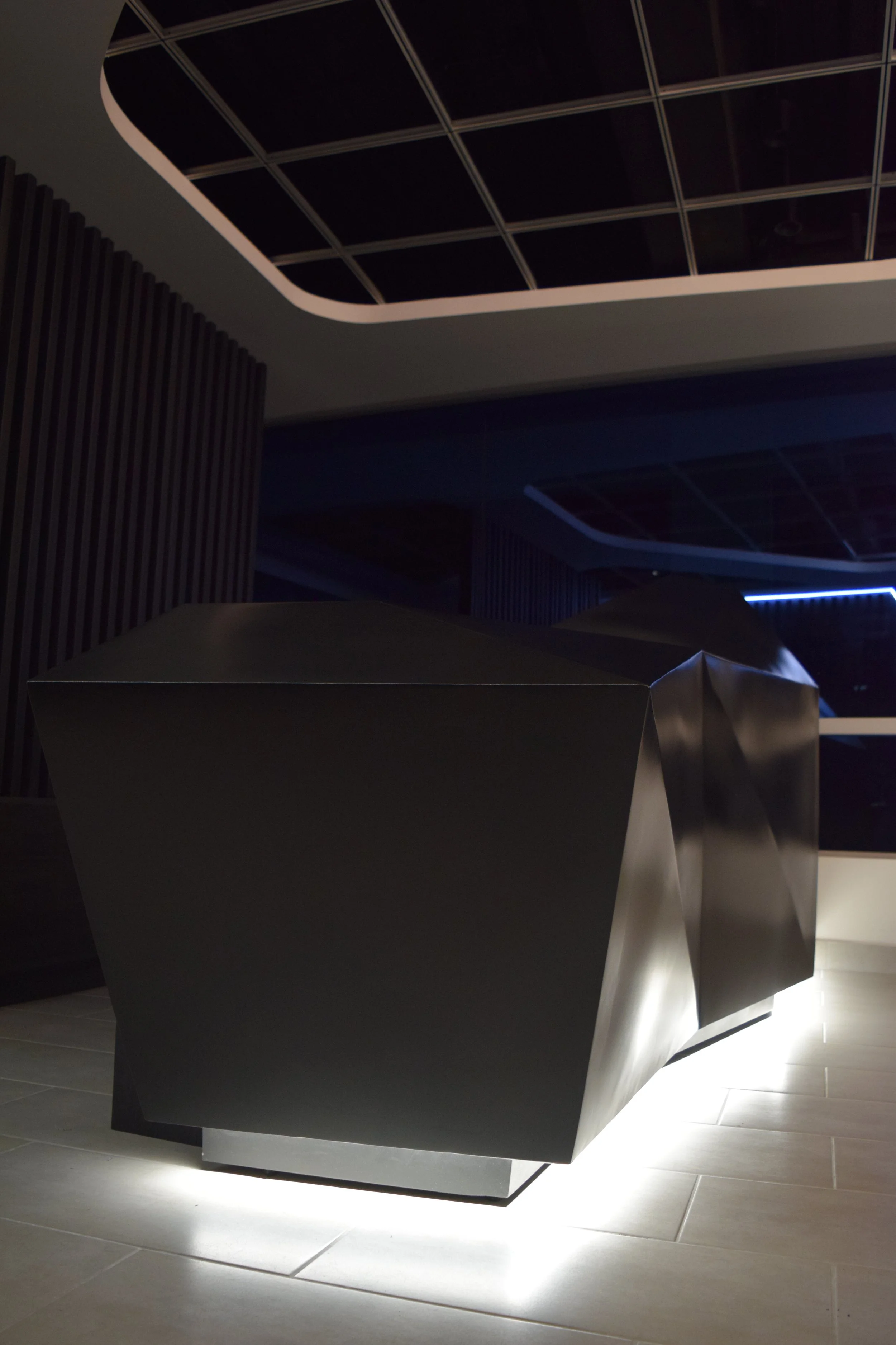 Estructura metálica moderna en un espacio interior con iluminación tenue y techos panelados.