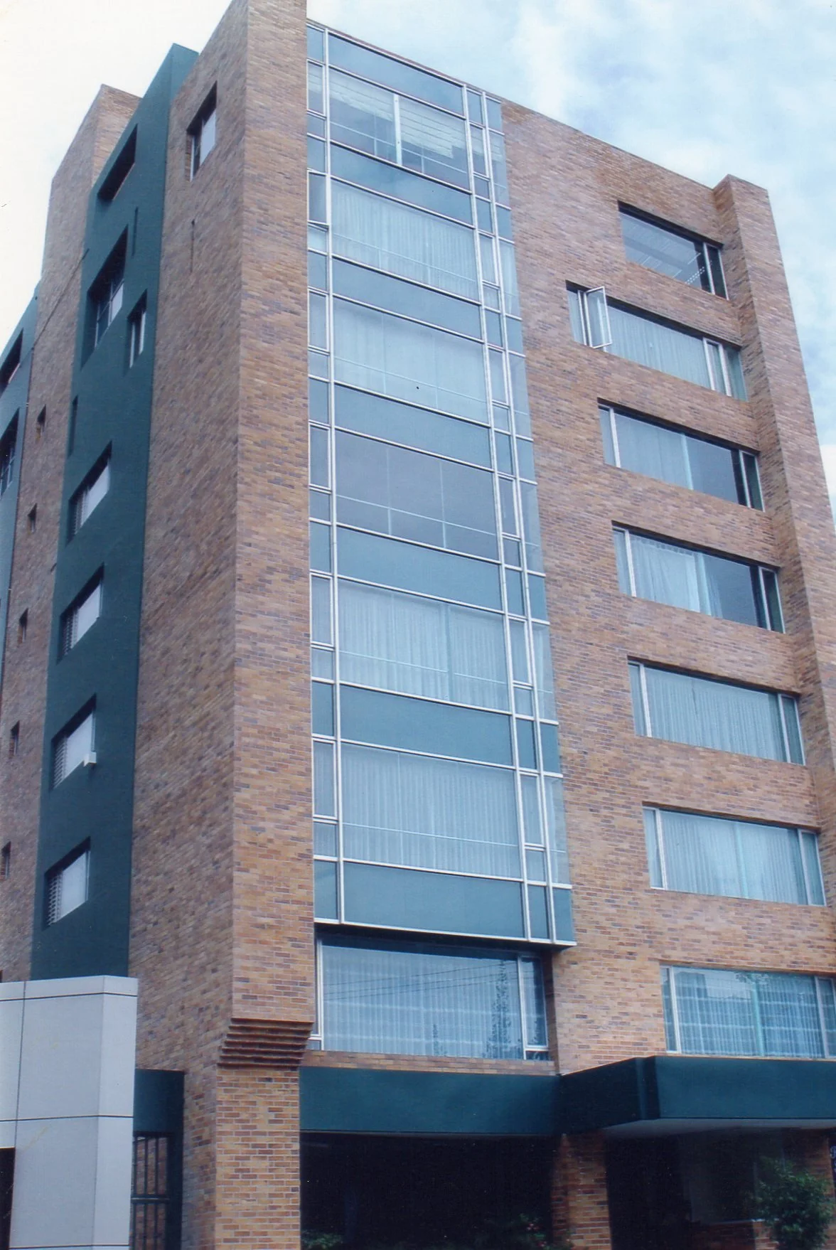 Edificio moderno de varios pisos construido con ladrillos y ventanas de vidrio.