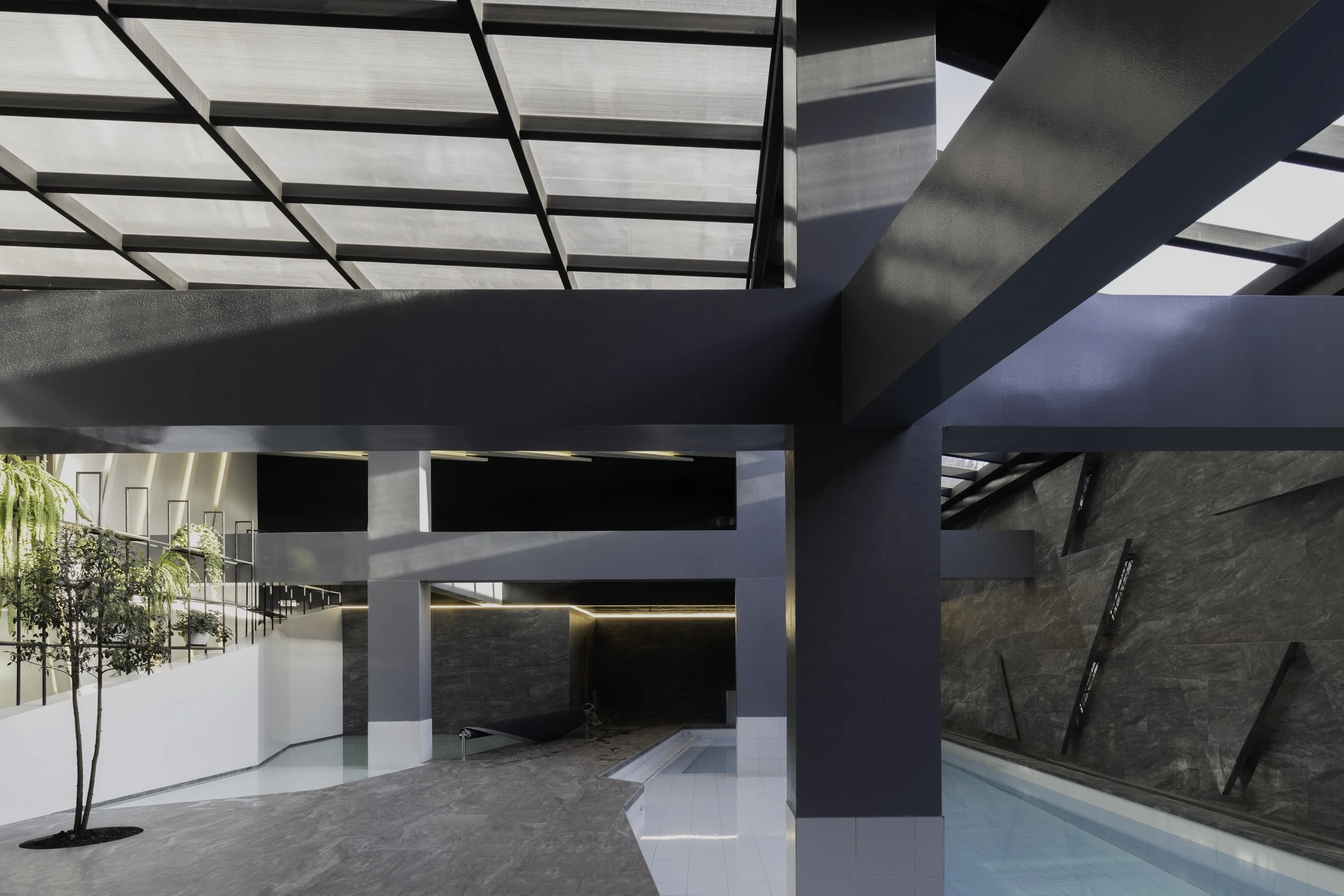 Interiores de un diseño moderno con piscina y estructura de metal y vidrio bajo techo de cristal