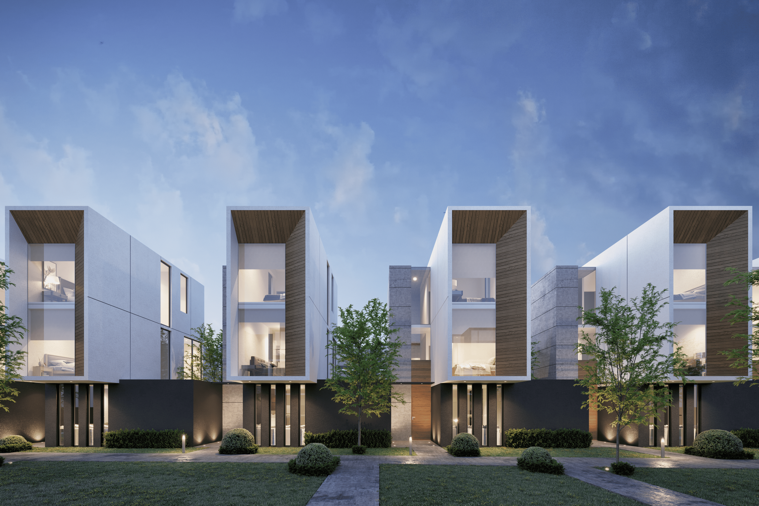 Conjunto de edificios residenciales modernos con ventanas grandes, en una noche con cielo despejado y árboles en el jardín.