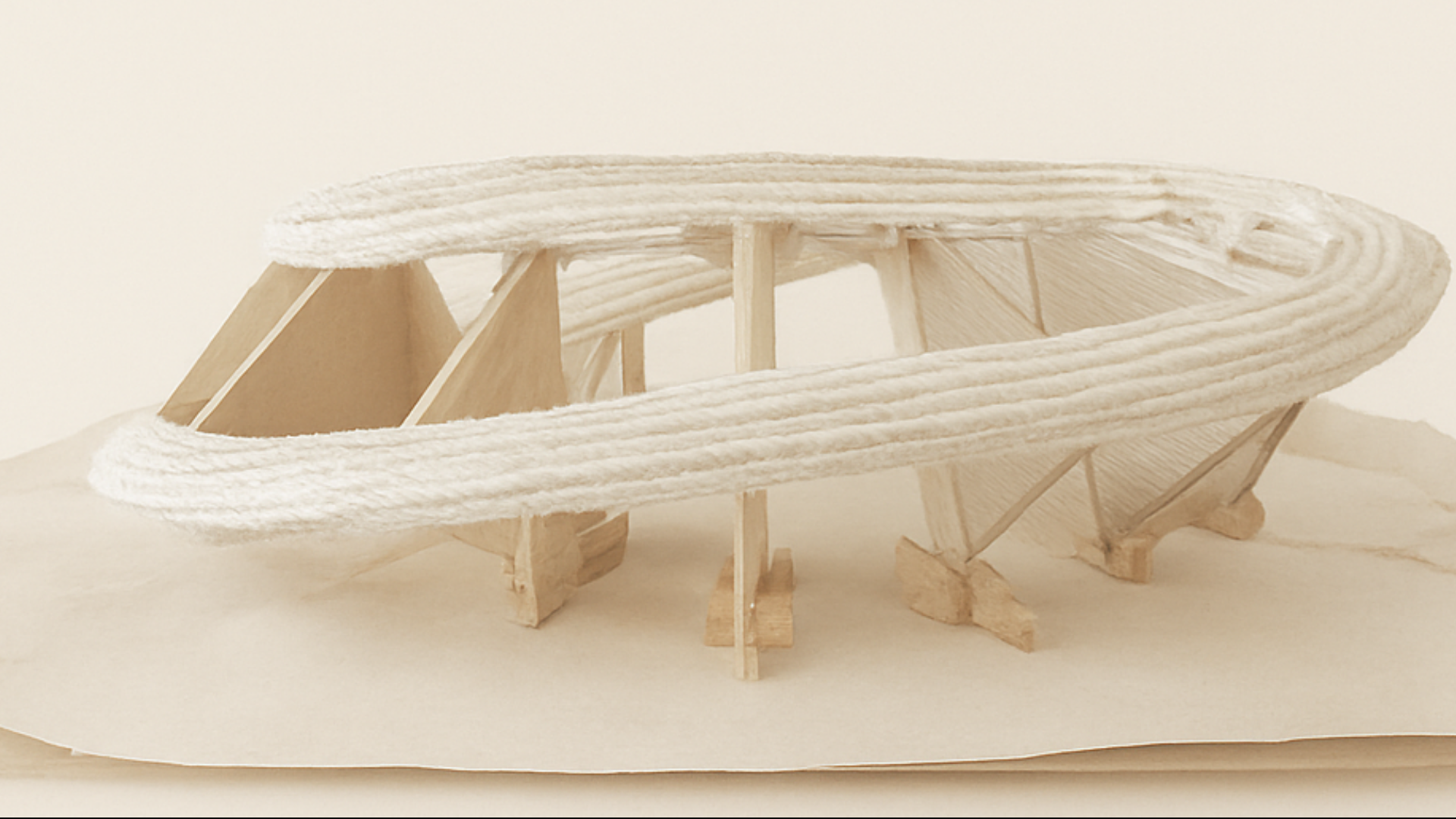 Modelo arquitectónico de una embarcación con estructura de madera y cuerdas, en escala de un barco antiguo.