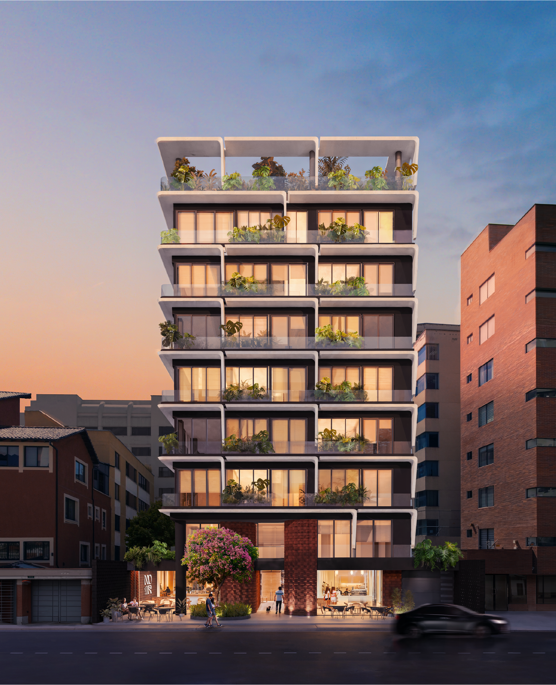 Edificio moderno de varios pisos con balcones llenos de plantas y ventanas grandes, en un entorno urbano al atardecer, con algunas personas y un automóvil en la calle.
