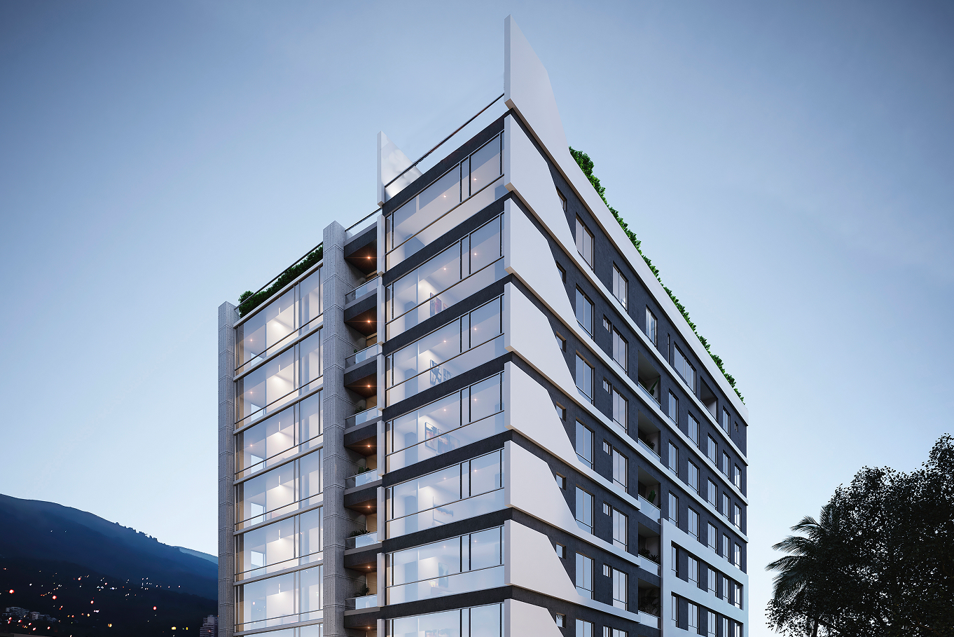 Edificio moderno de varios pisos con fachada de vidrio y áreas de balcones, rodeado de naturaleza y con cielo despejado.