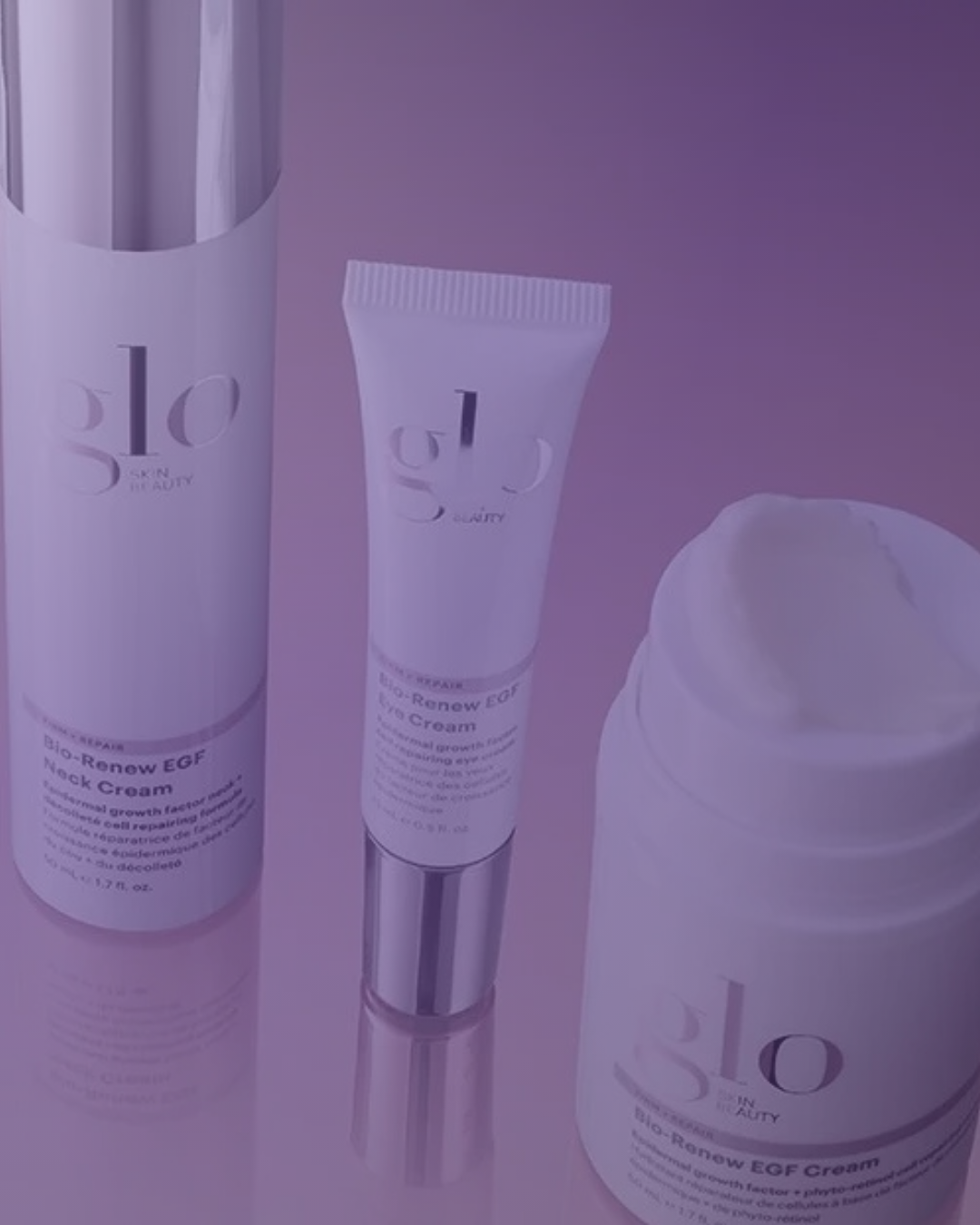 Three skincare products from the brand glo, including a large cylindrical bottle, a tube, and a jar, placed against a purple background.