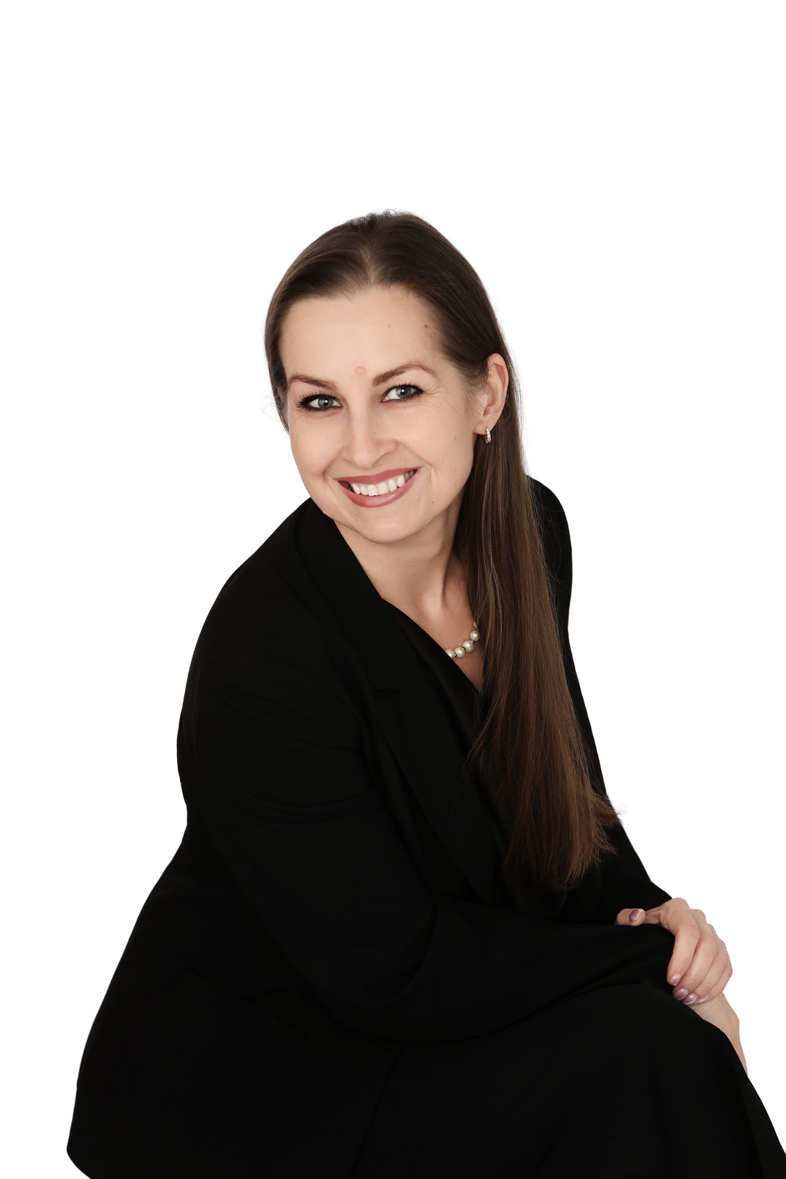 Adriana, experienced esthetician at Skin Studio, smiling in a professional portrait while wearing a black suit.