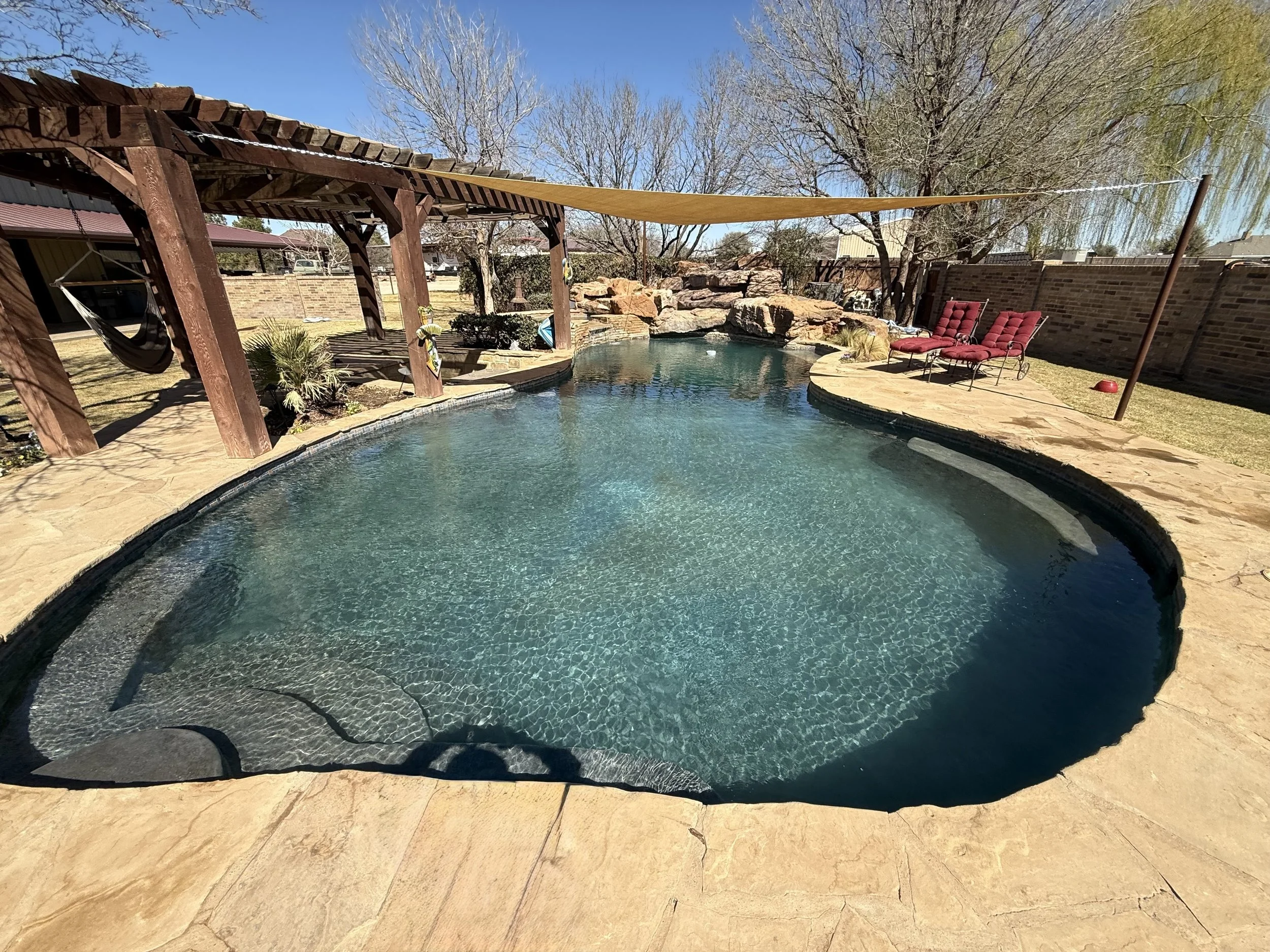Clean, clear pool water after recovery treatment with patio seating.