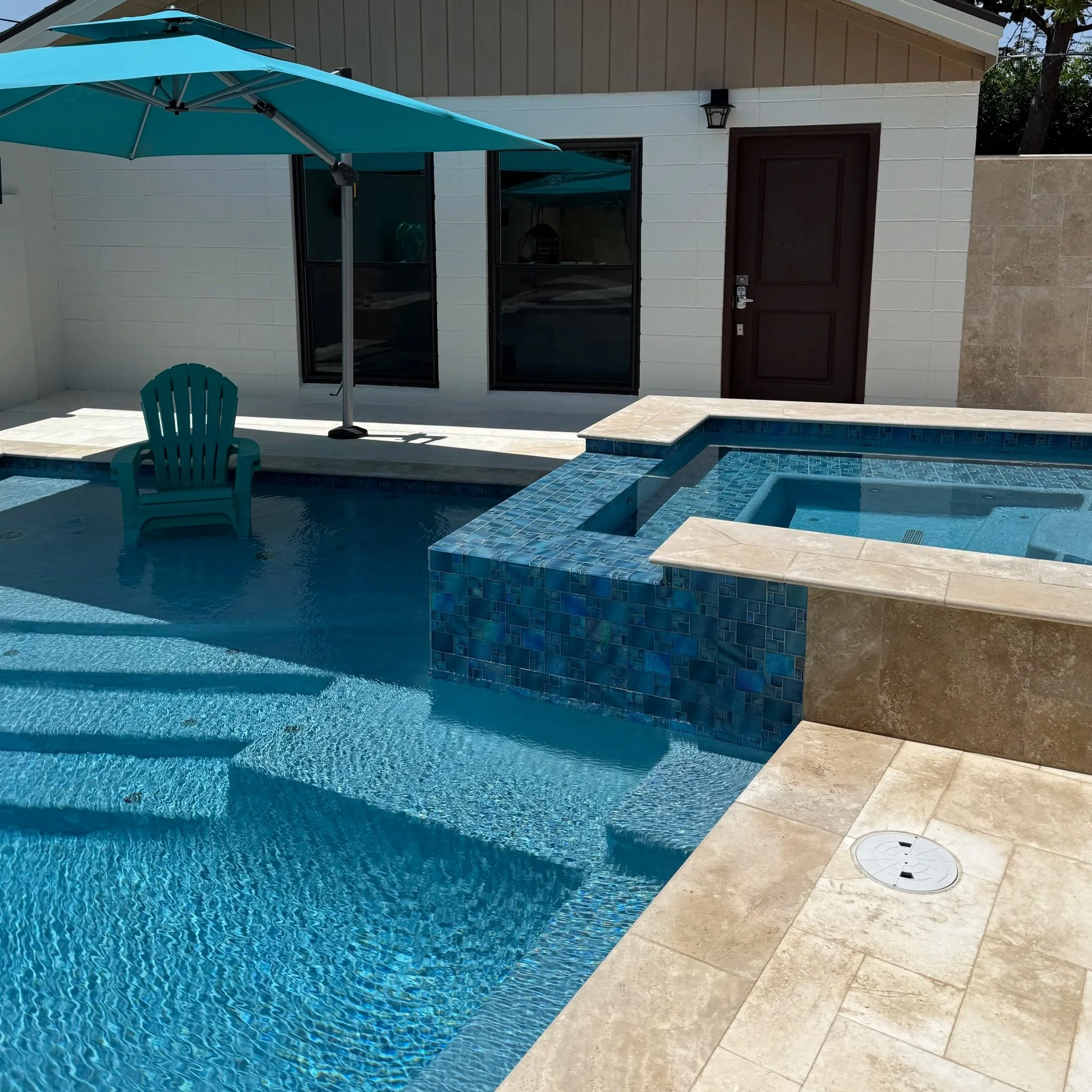 Modern residential pool with clear blue water and a raised spa, representing weekly pool cleaning services in Midland, Texas.