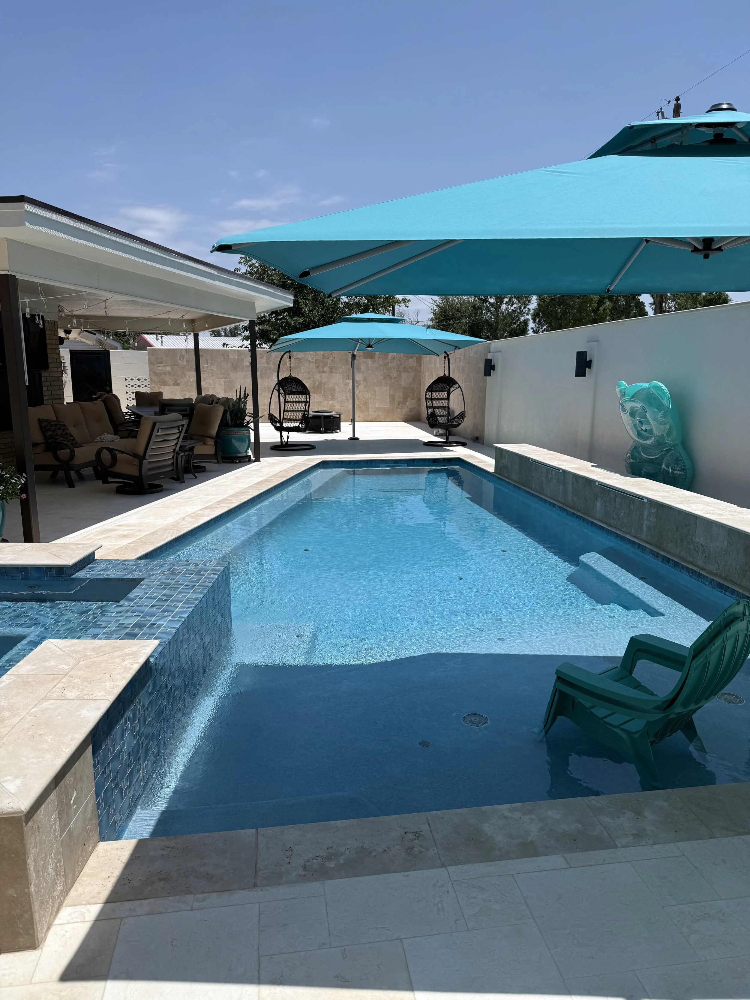 Clean residential pool with lounge chairs and umbrellas in Midland, Texas.