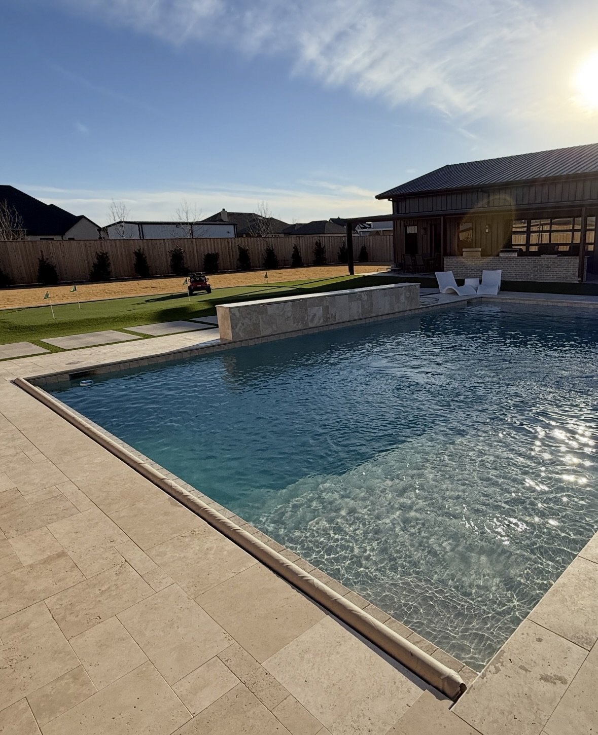 Backyard pool in Midland, Texas reflecting sunset light on clear water.