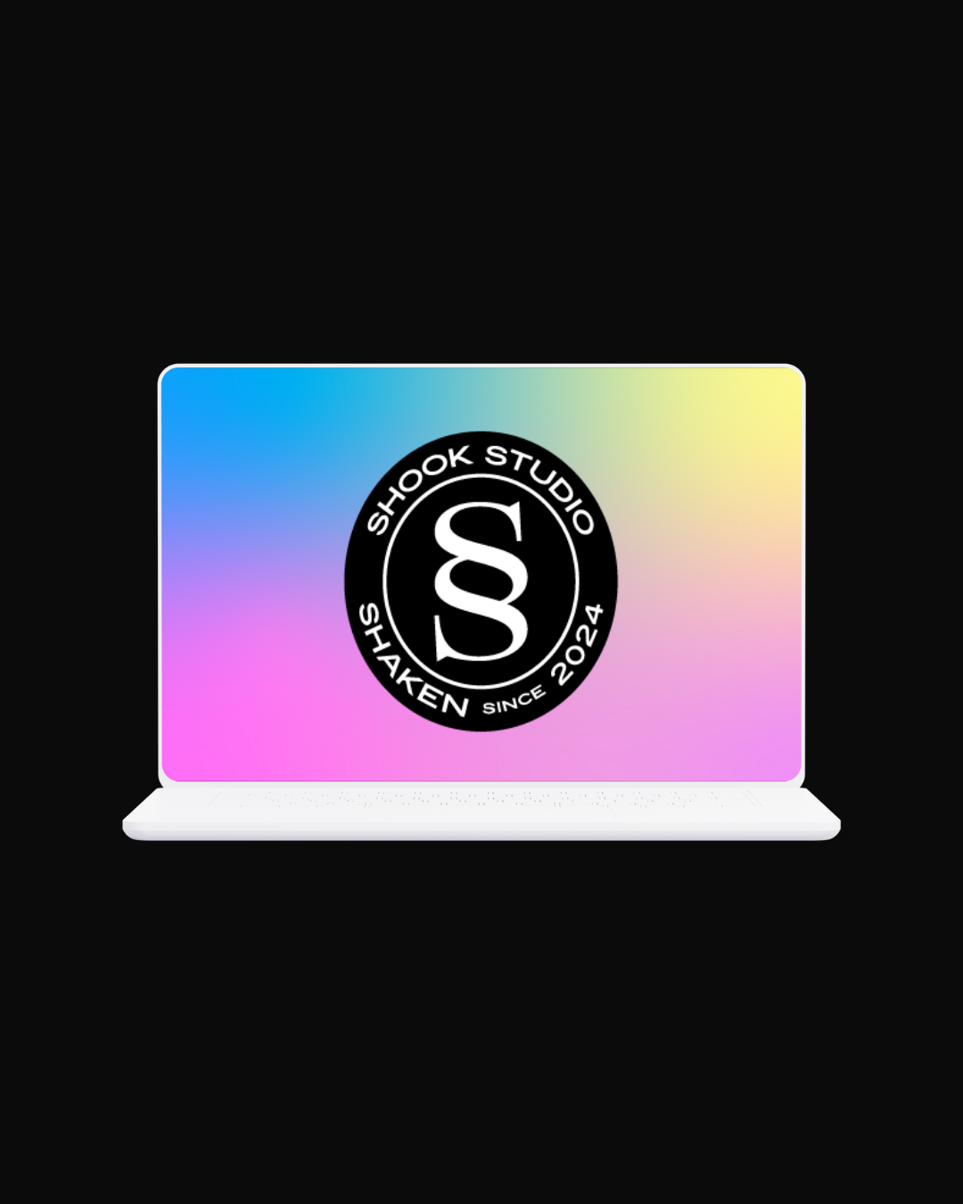 A laptop with a colorful gradient screen displaying a logo for Shook Studio, featuring a black circle with white text and a stylized "S" in the center, on a black background.